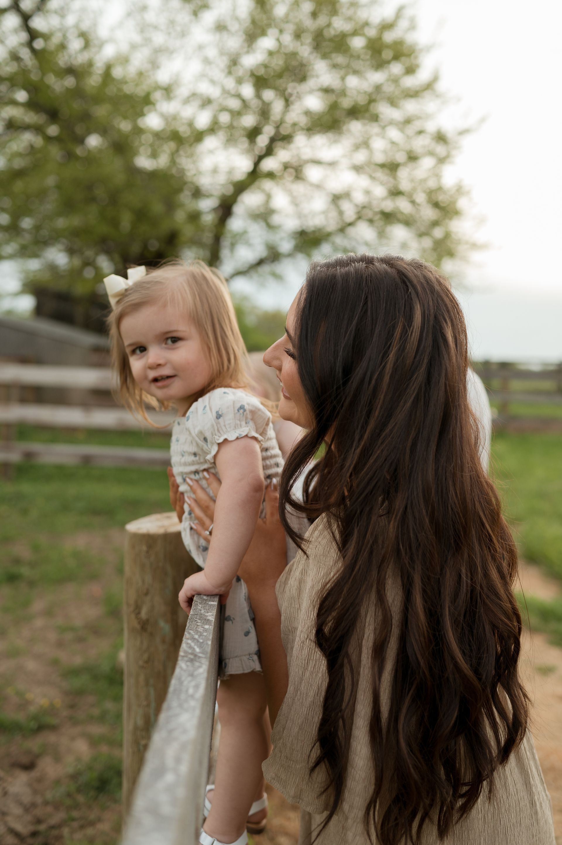 A woman is holding a little girl in her arms in a field.