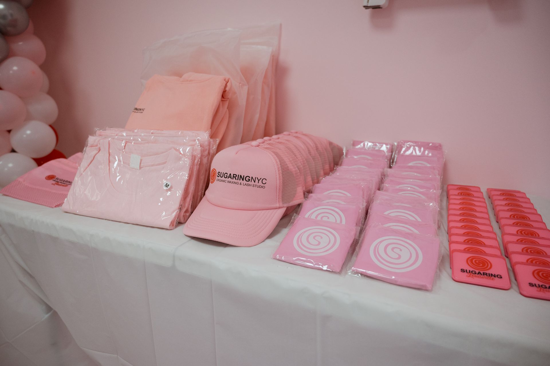 A table with a bunch of pink items on it.