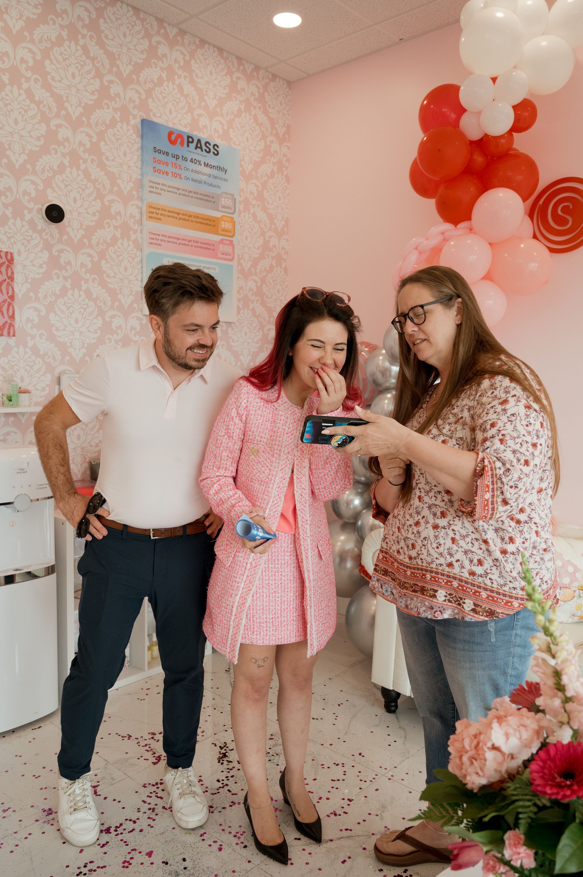 A group of people are standing next to each other in a room with balloons.