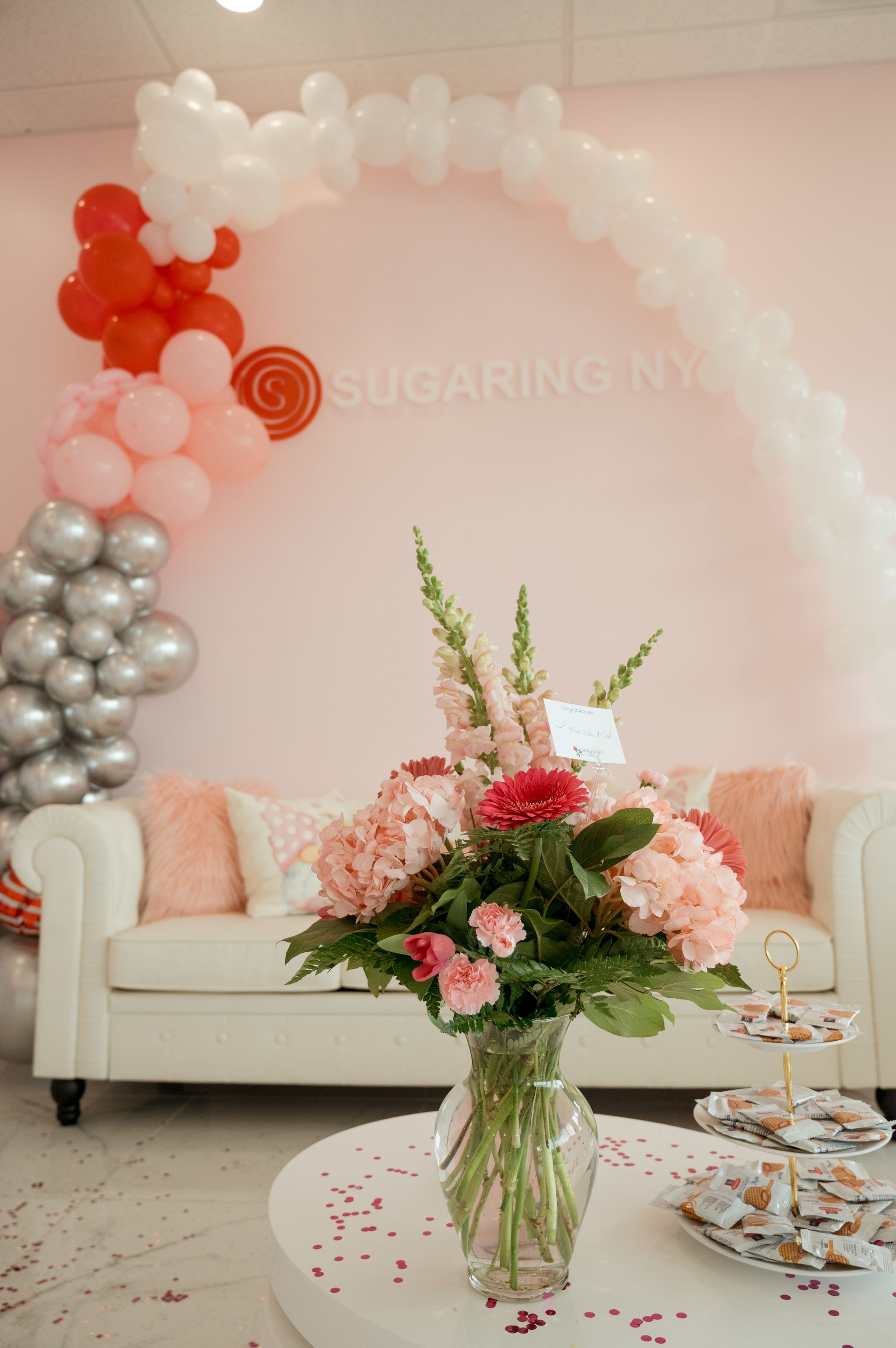 A vase of flowers is sitting on a table in front of a couch.