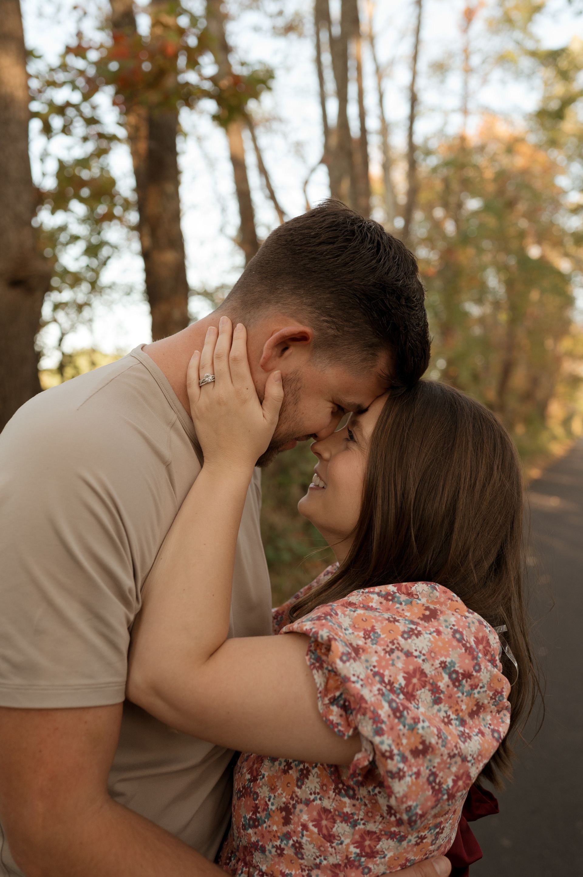 A man and a woman are kissing in the woods.