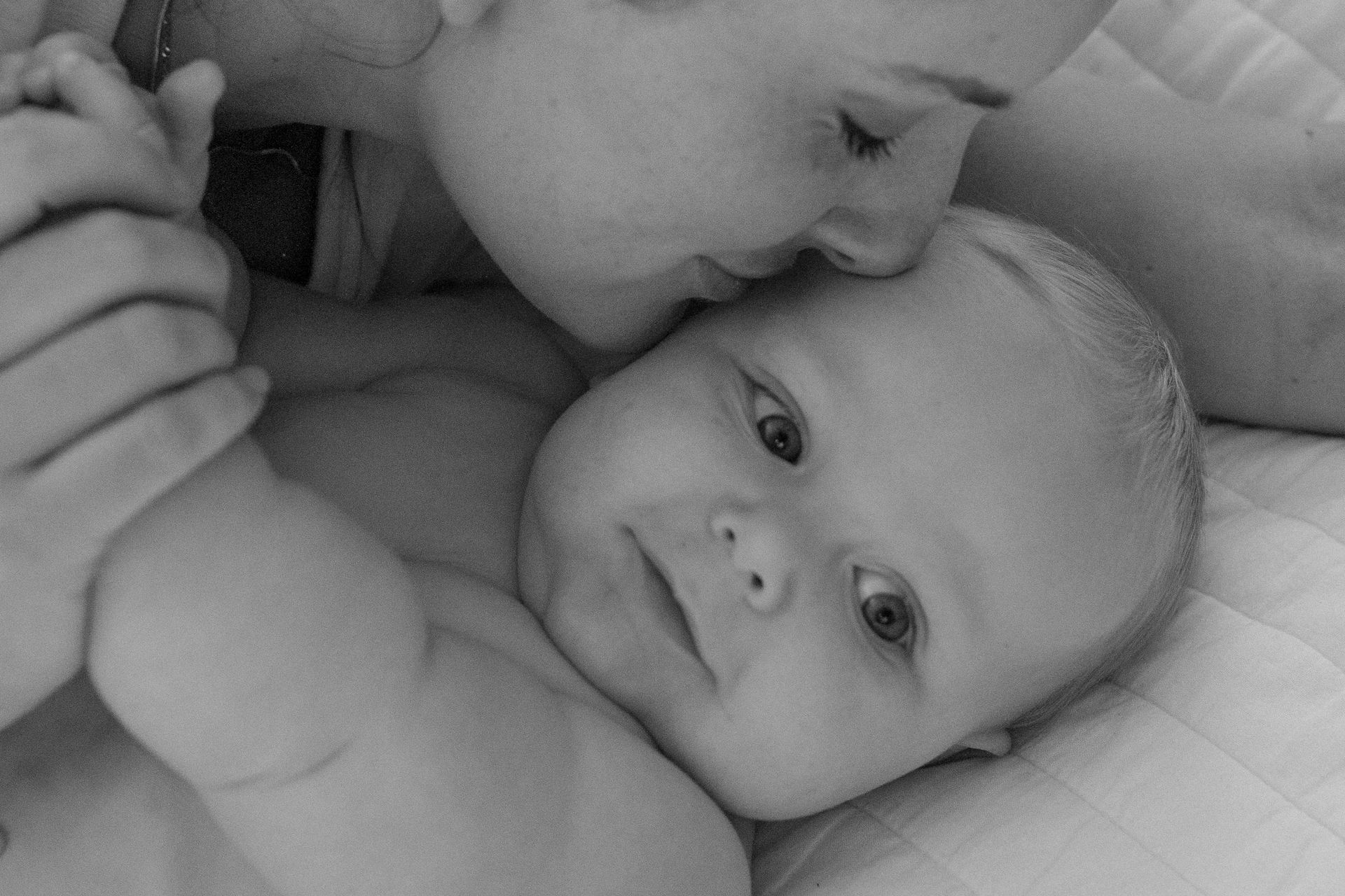 A mom kissing her baby