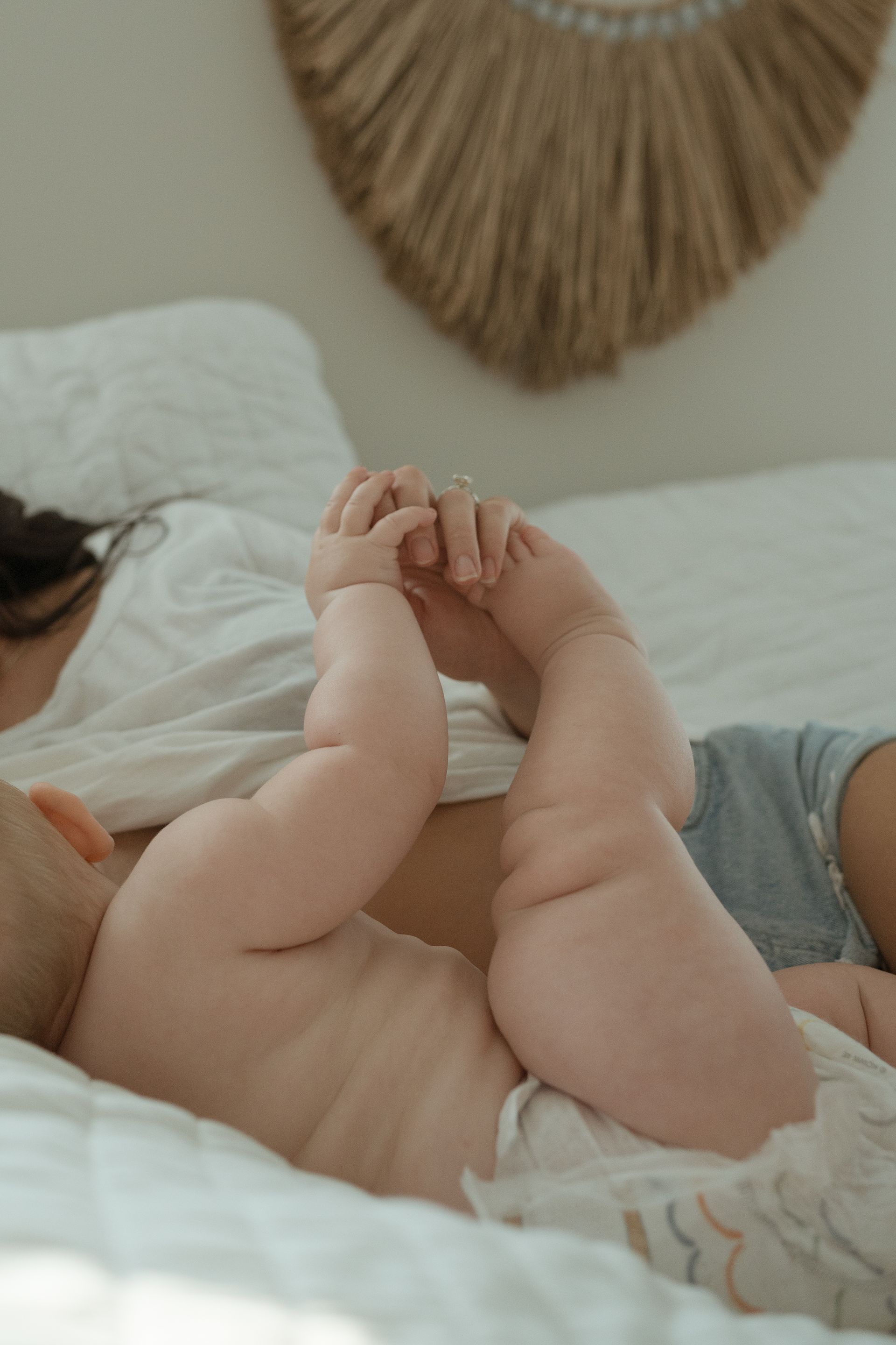 A mom and baby laying in bed