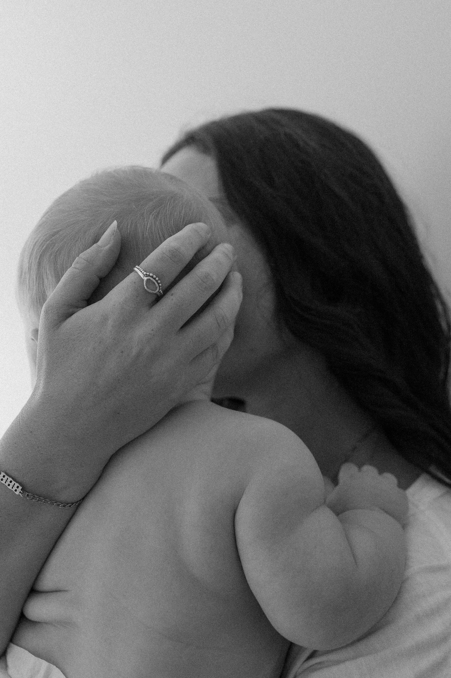 A woman is holding a baby in her arms in a black and white photo.