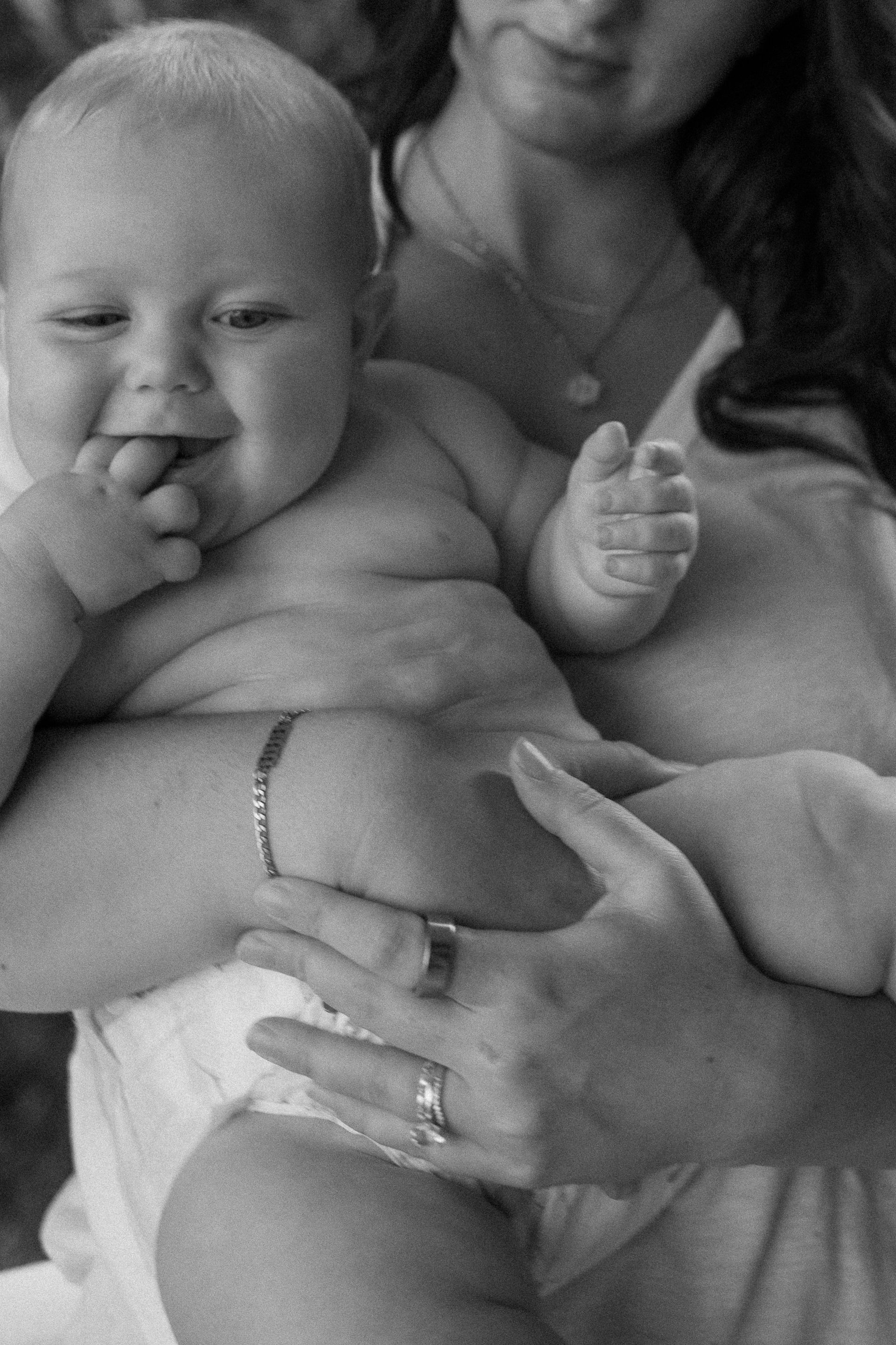 A woman is holding a baby in her arms and the baby is smiling.