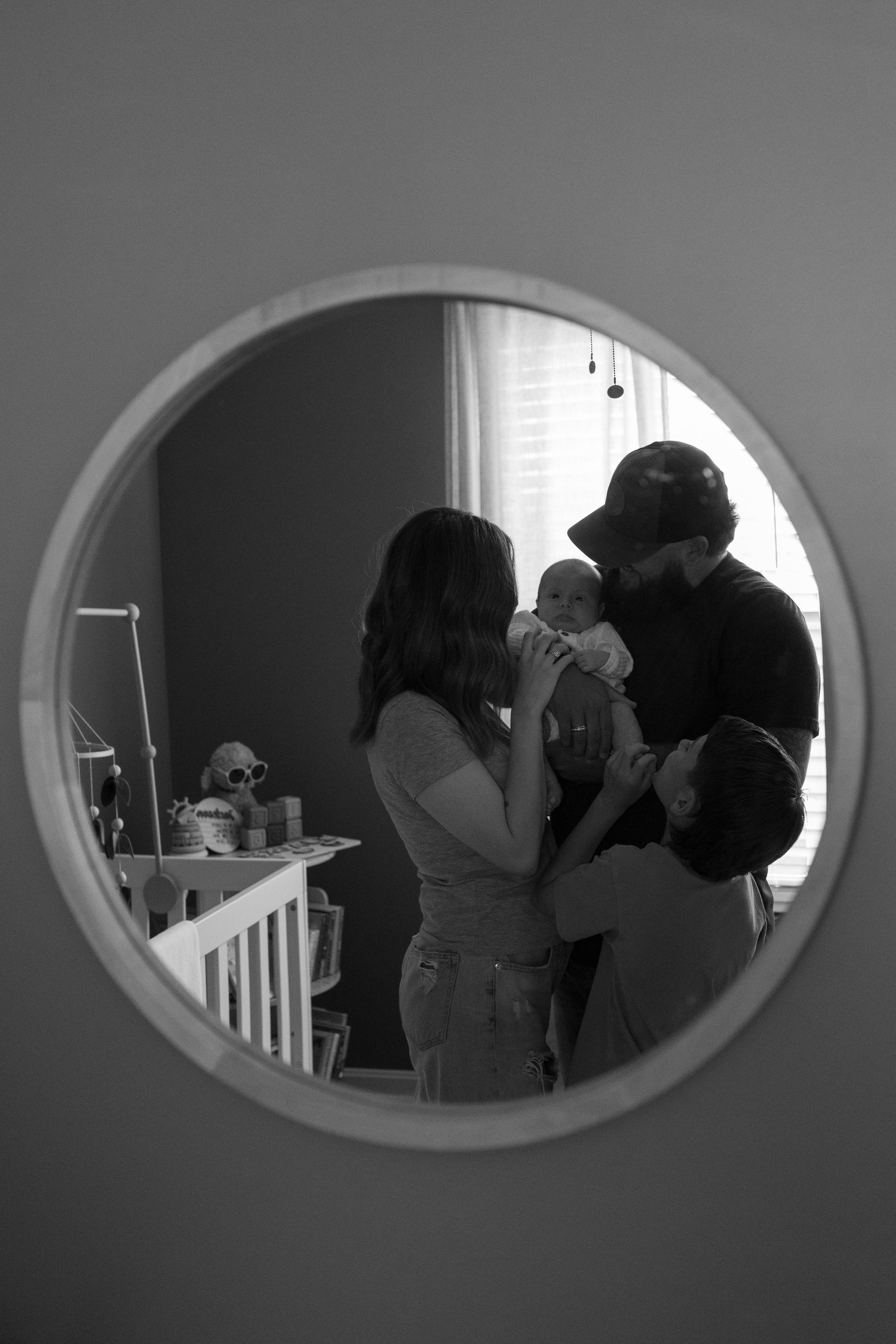 A black and white photo of a family in a nursery
