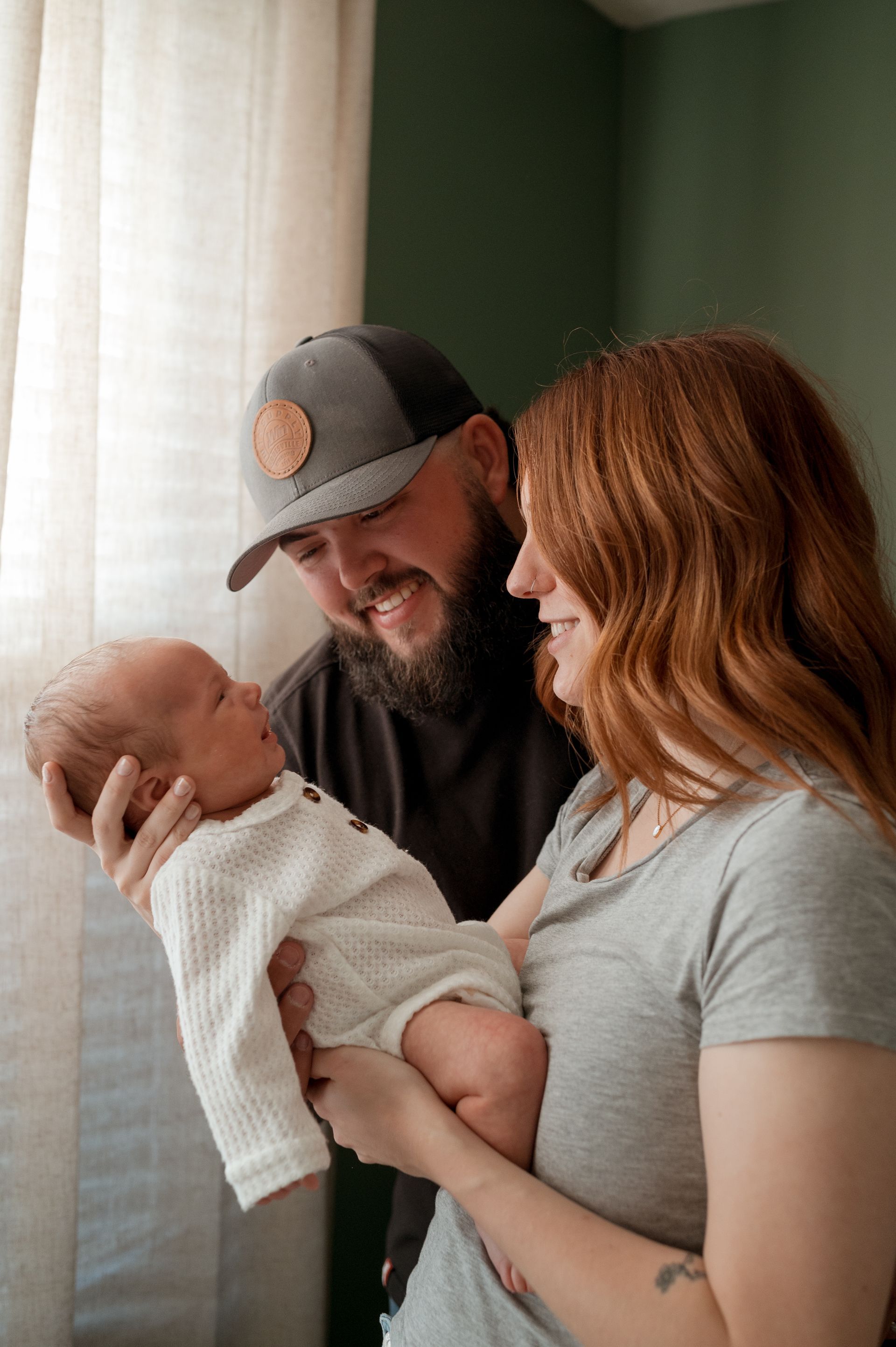 A man and a woman are holding a baby in their arms.