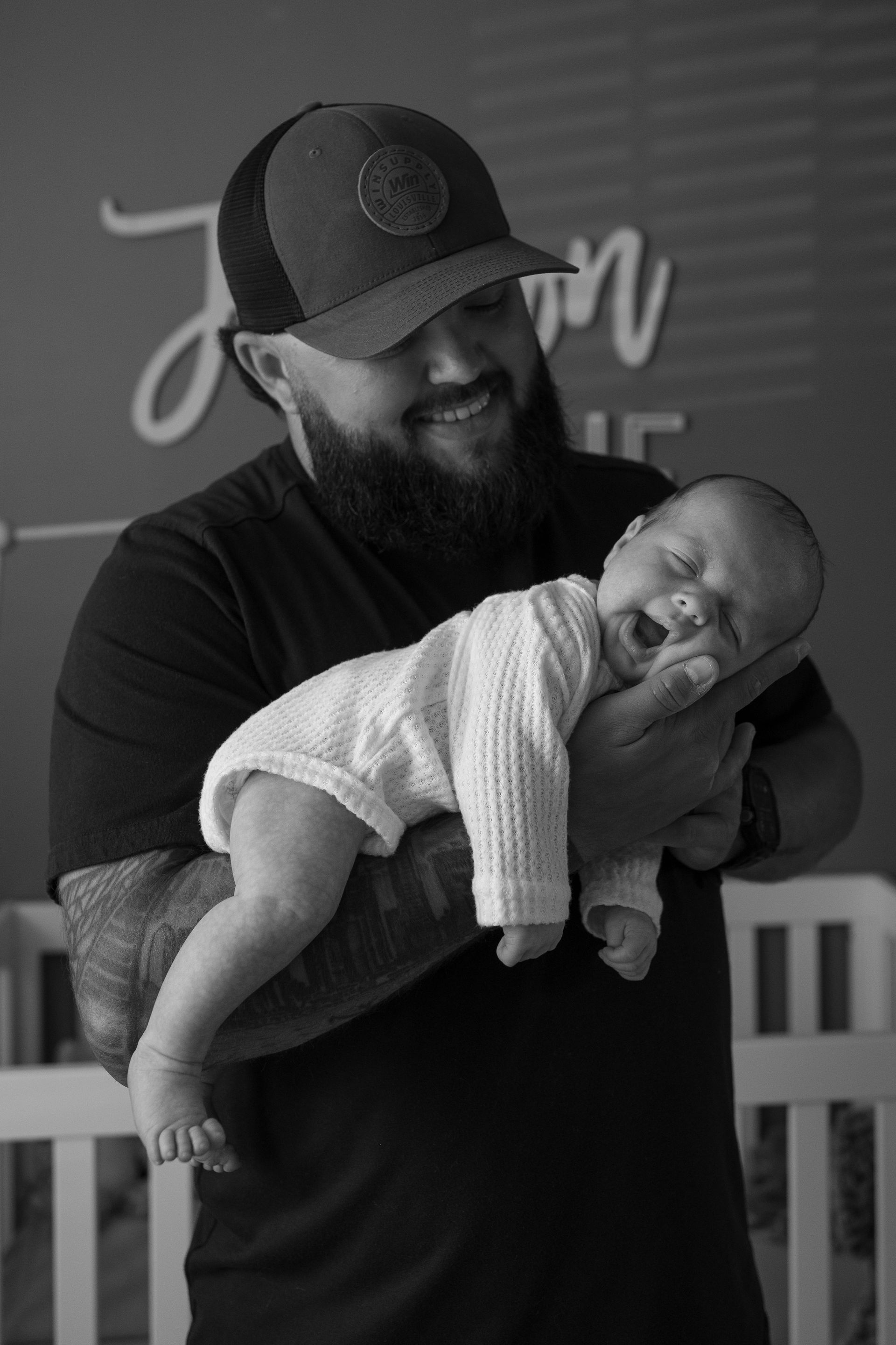 A man with a beard is holding a baby in his arms.
