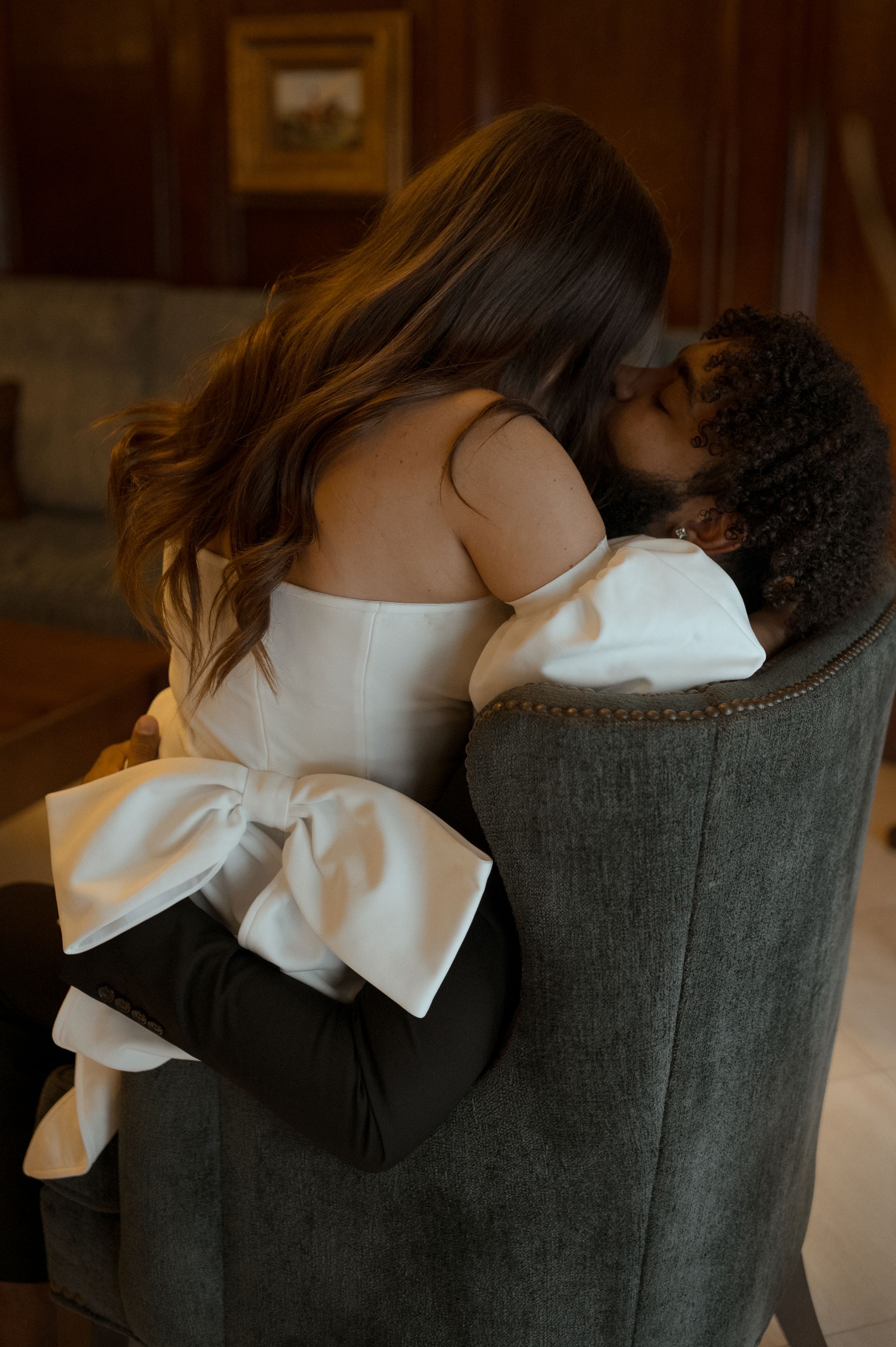 A man and a woman are hugging each other while sitting in a chair.