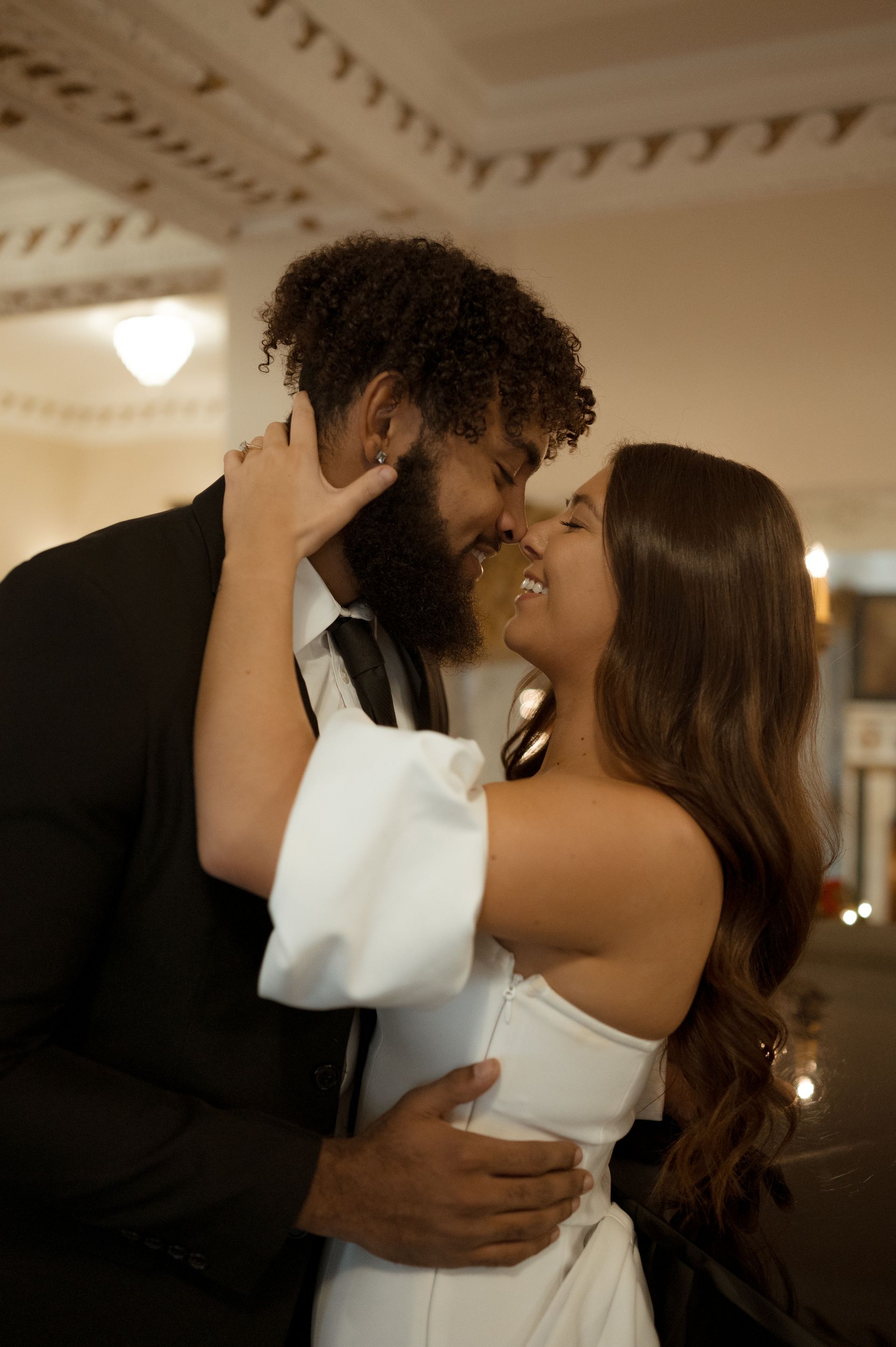 A man and a woman are kissing in a room.