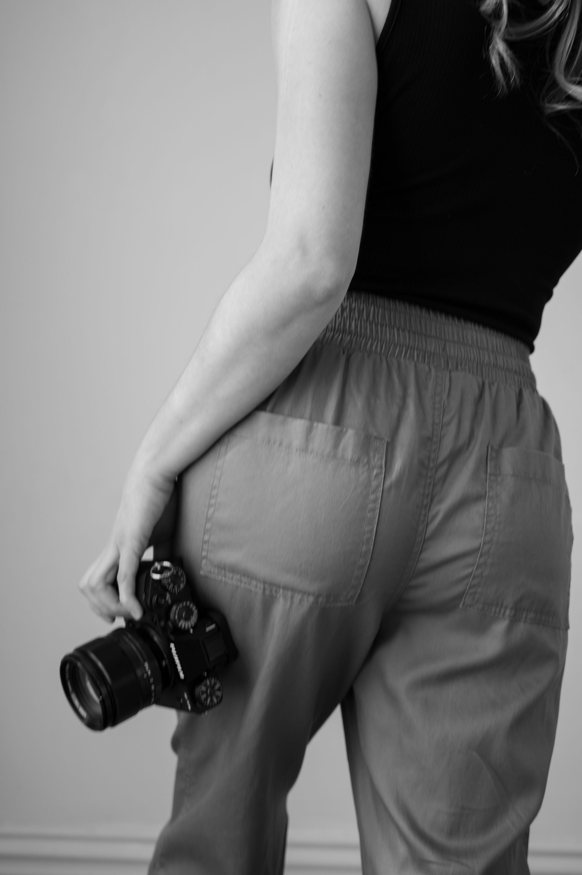 A black and white photo of a woman holding a camera