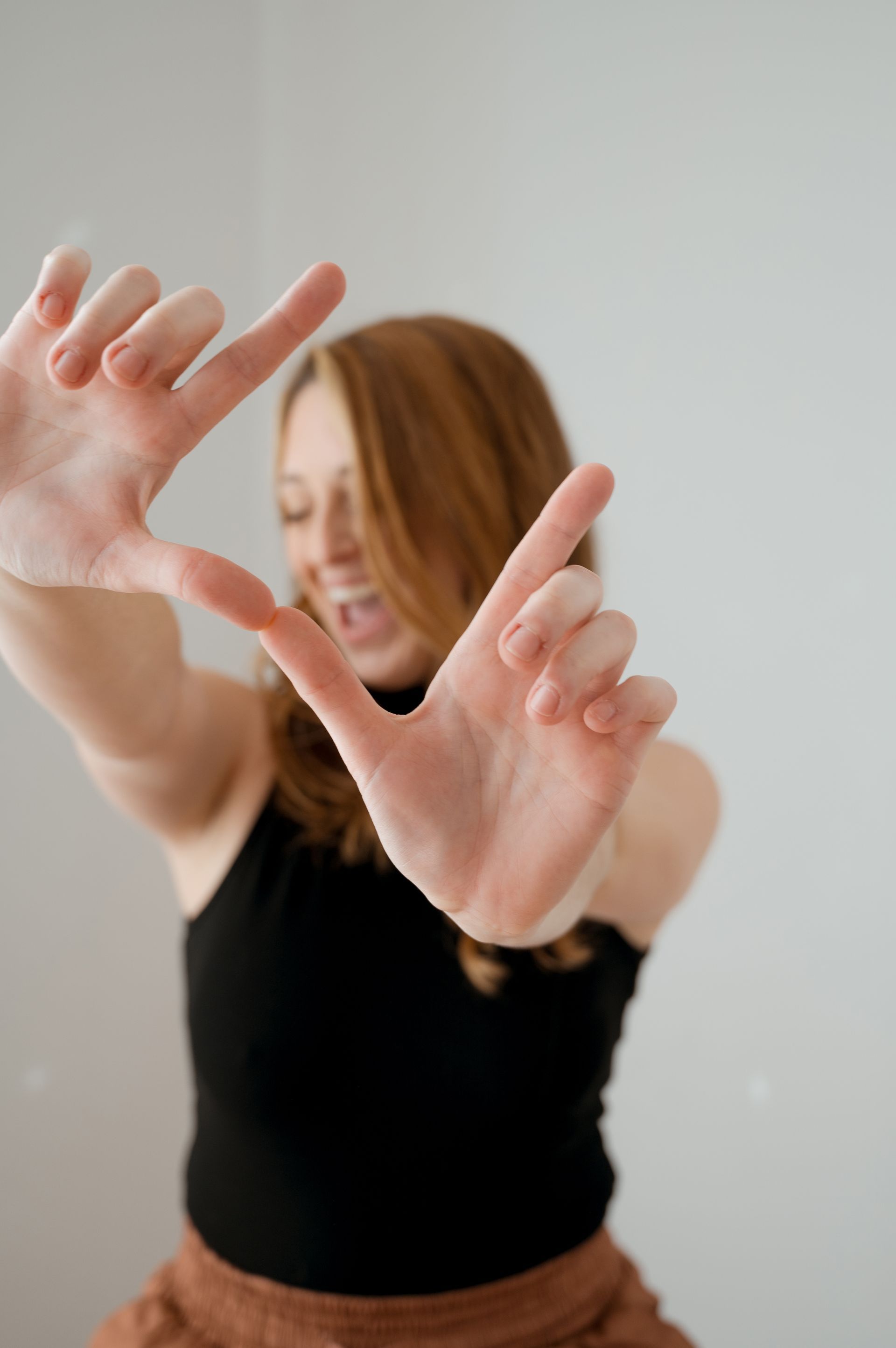 A woman is making a frame with her hands.