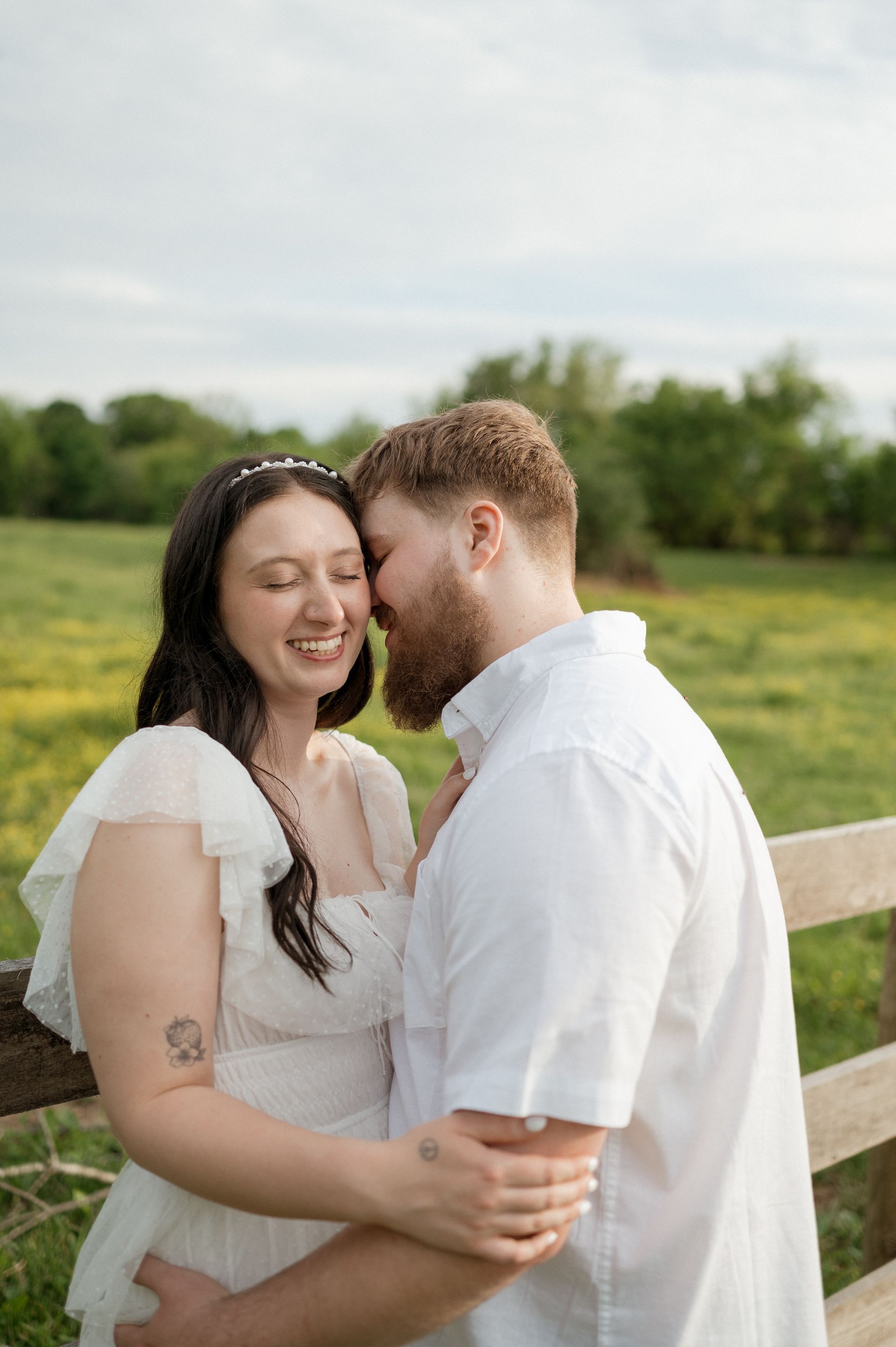 A man and a woman are kissing in a field.