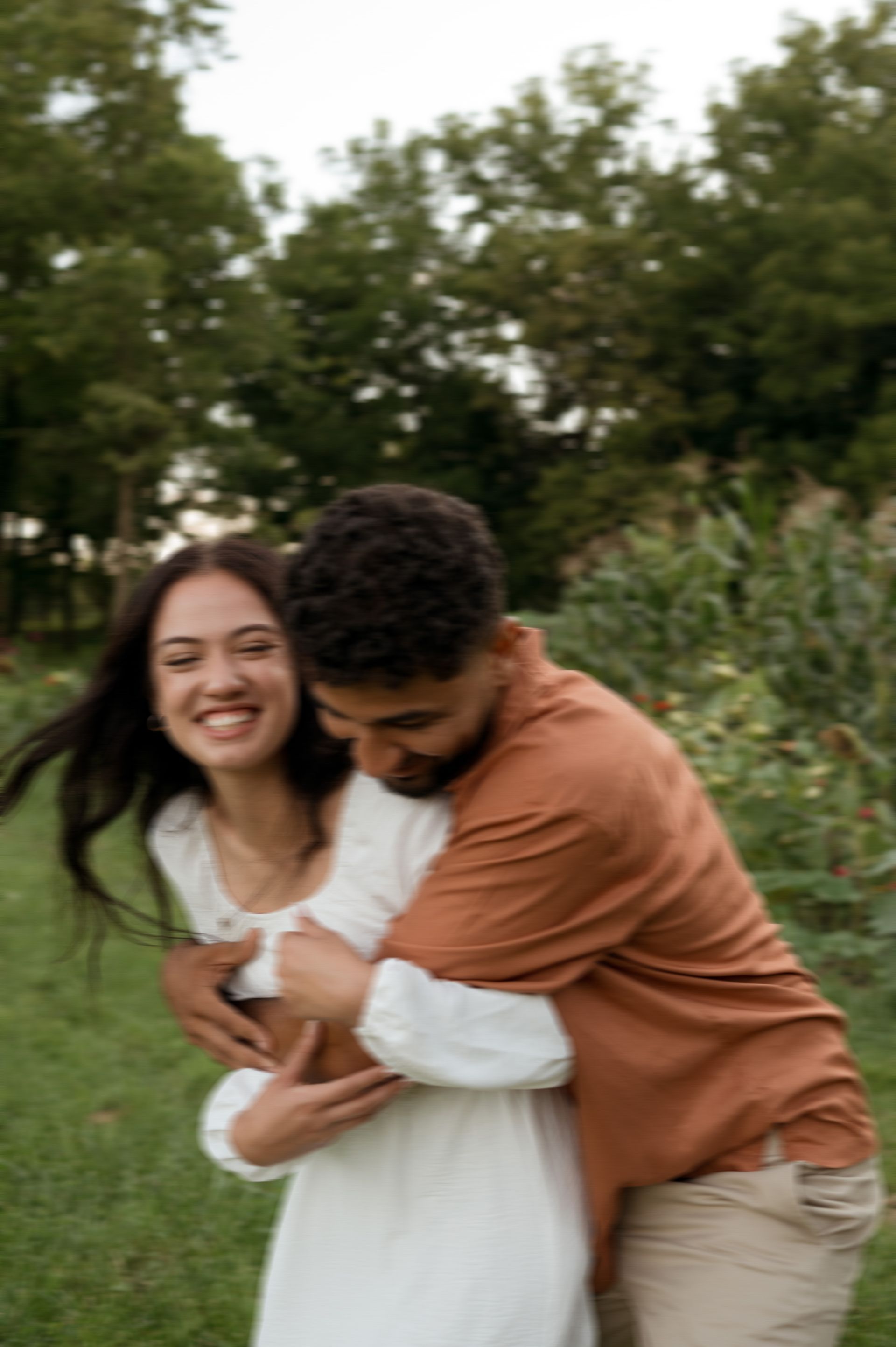 A man is holding a woman in his arms in a park.