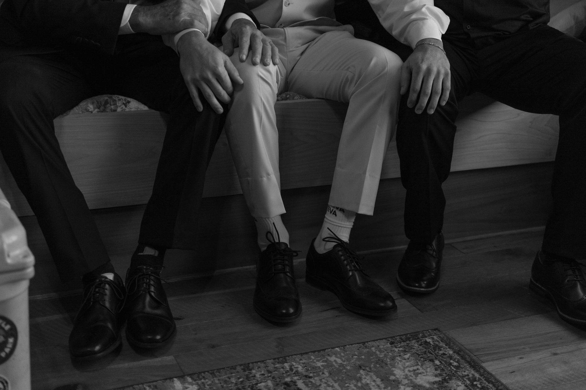A black and white photo of three men sitting next to each other.