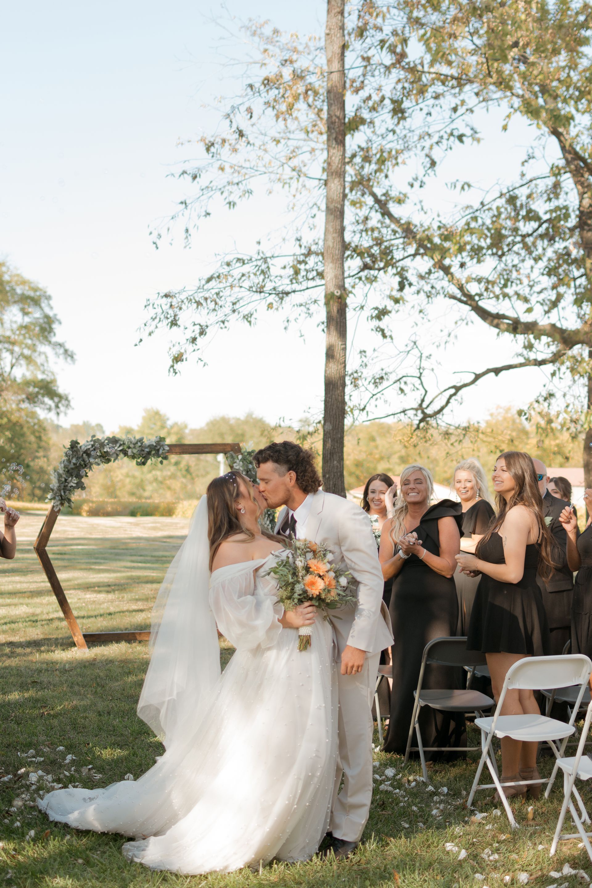 A bride and groom kissing during their wedding ceremony.