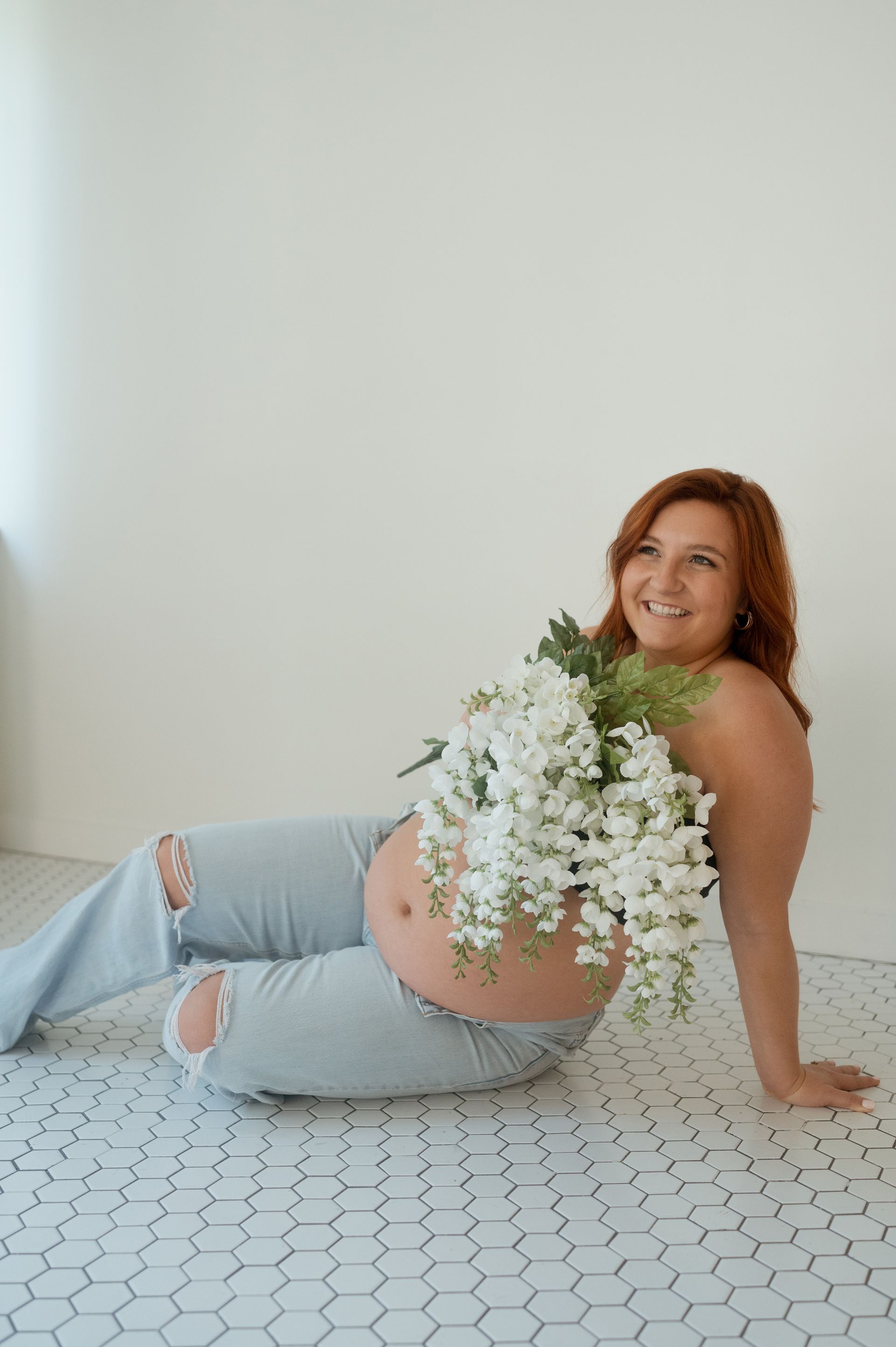 A Maternity photoshoot with a woman and flowers covering her top half
