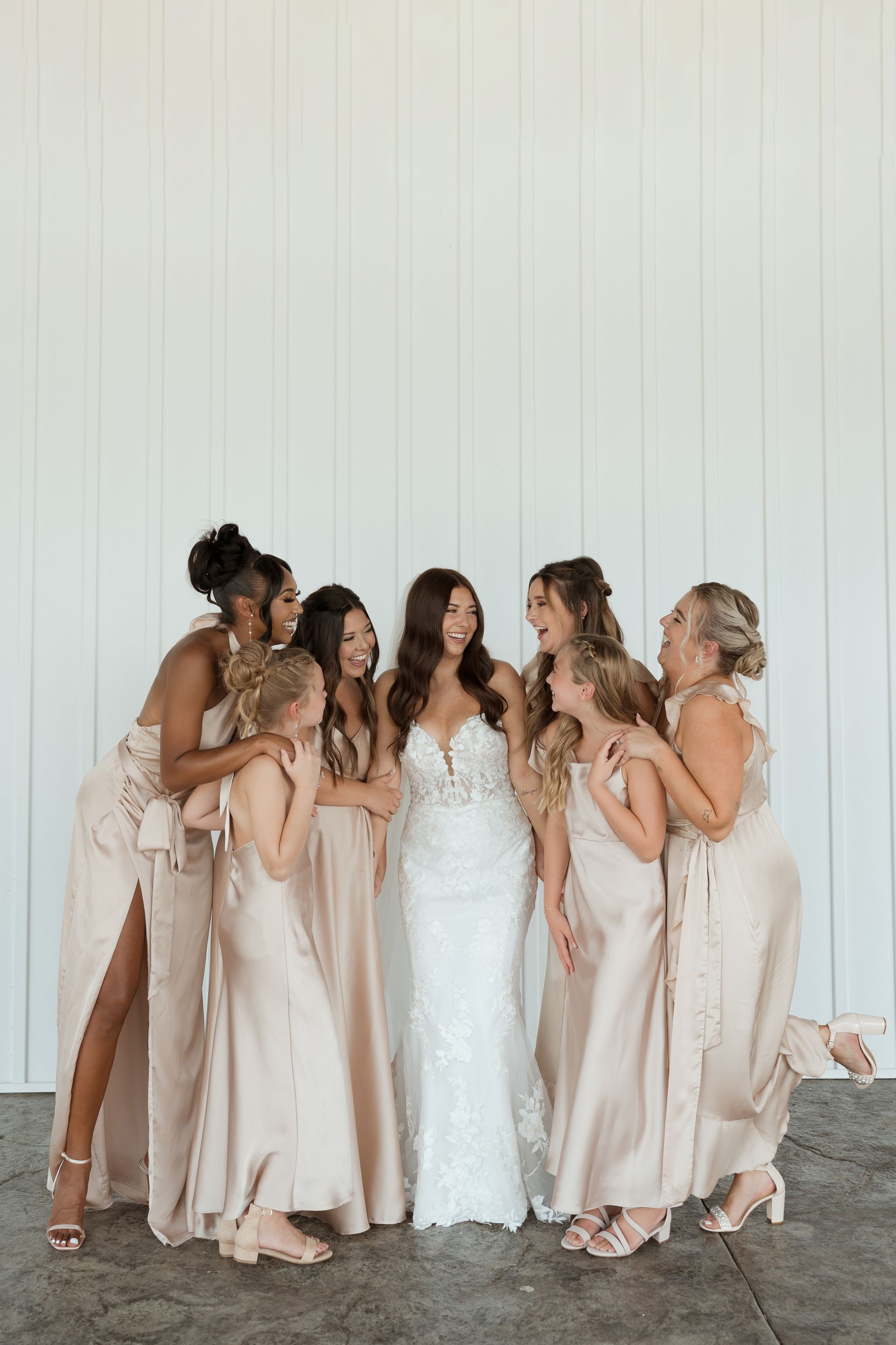 A bride and her bridesmaids are posing for a picture together.