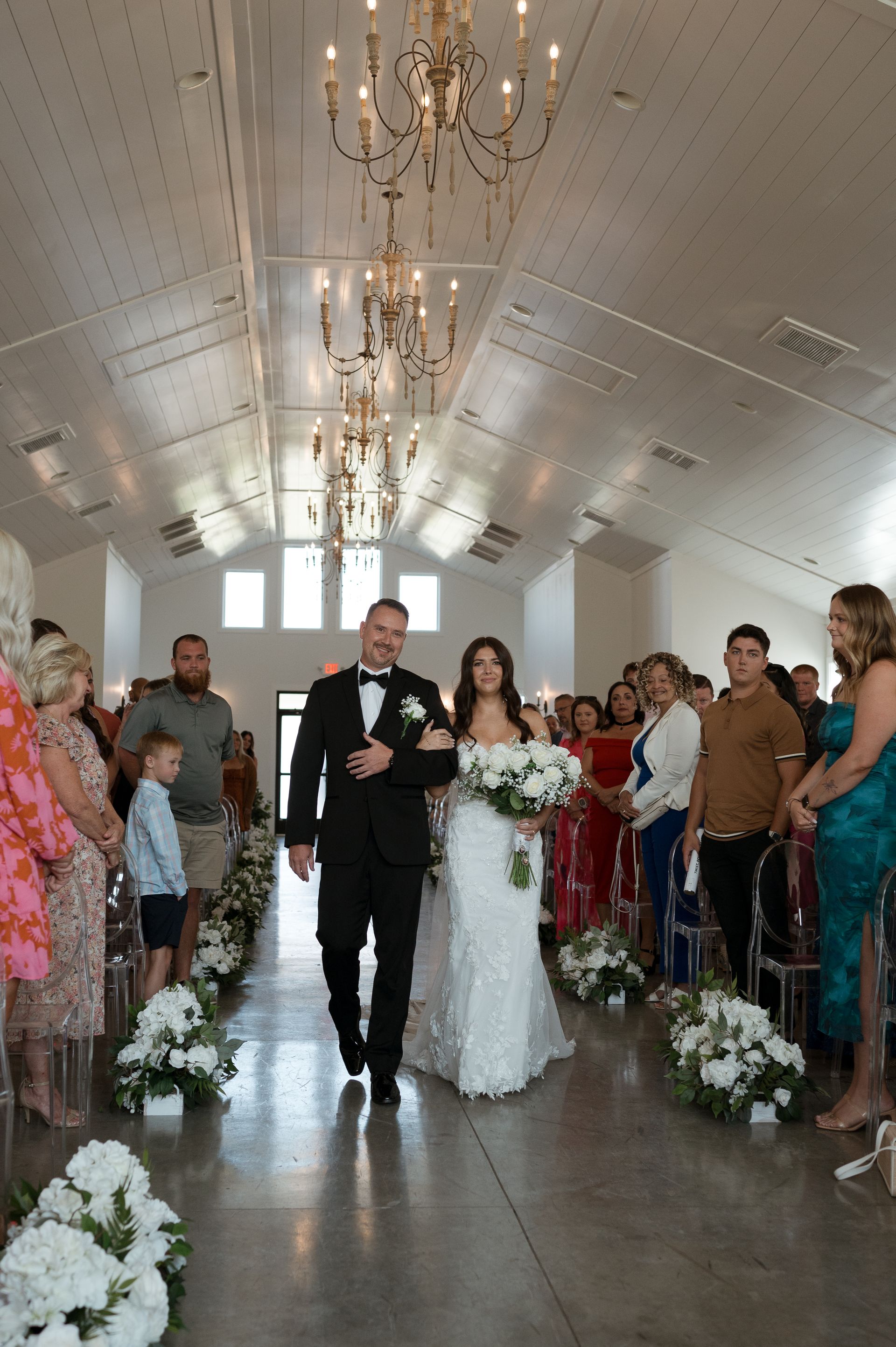 A bride and groom are walking down the aisle at their wedding.