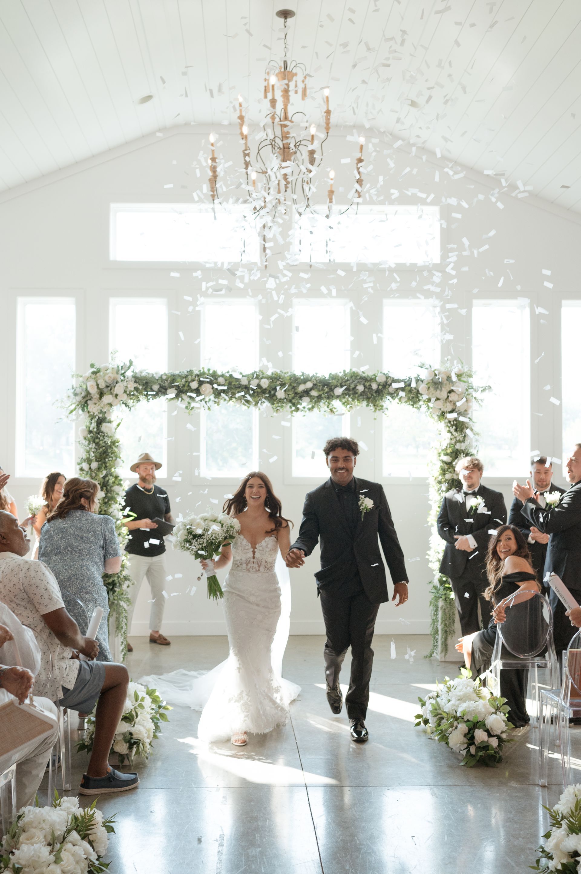 A bride and groom are walking down the aisle at their wedding ceremony.