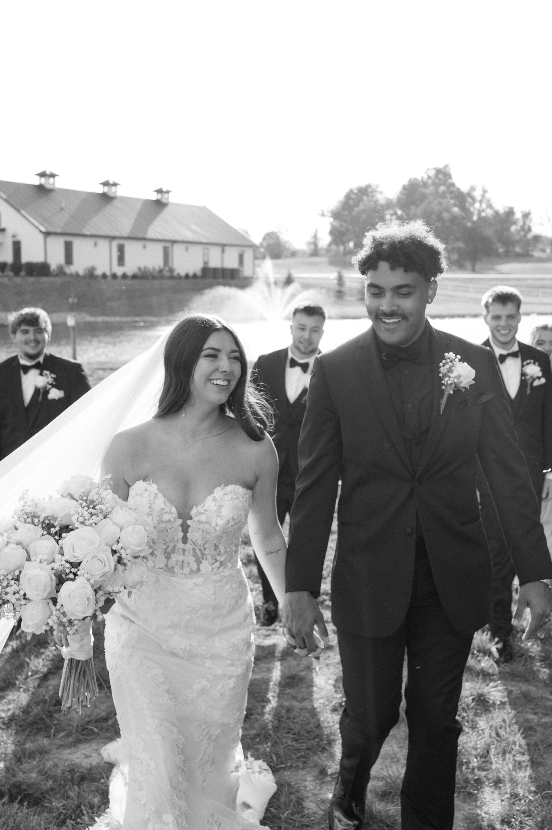 A bride and groom are walking down the aisle with their wedding party.