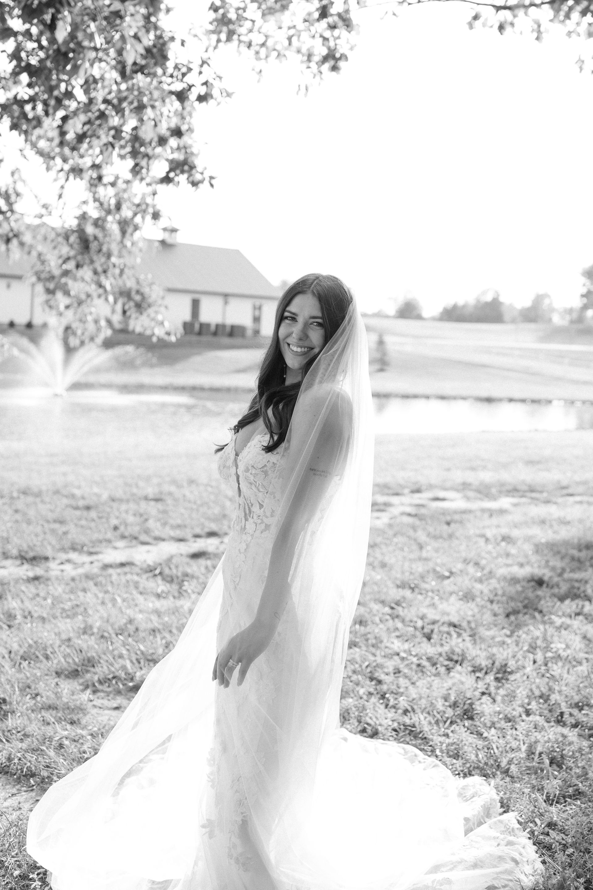 A black and white photo of a bride in a wedding dress and veil.