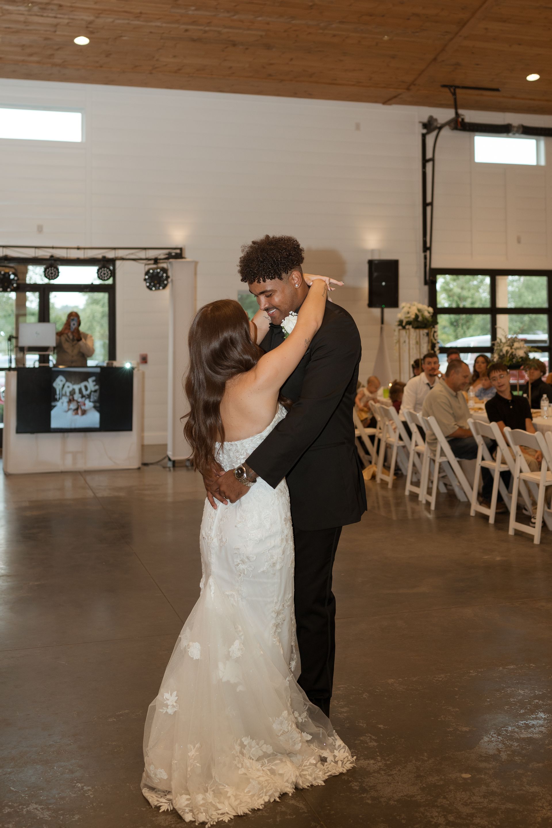A bride and groom are dancing at their wedding reception.
