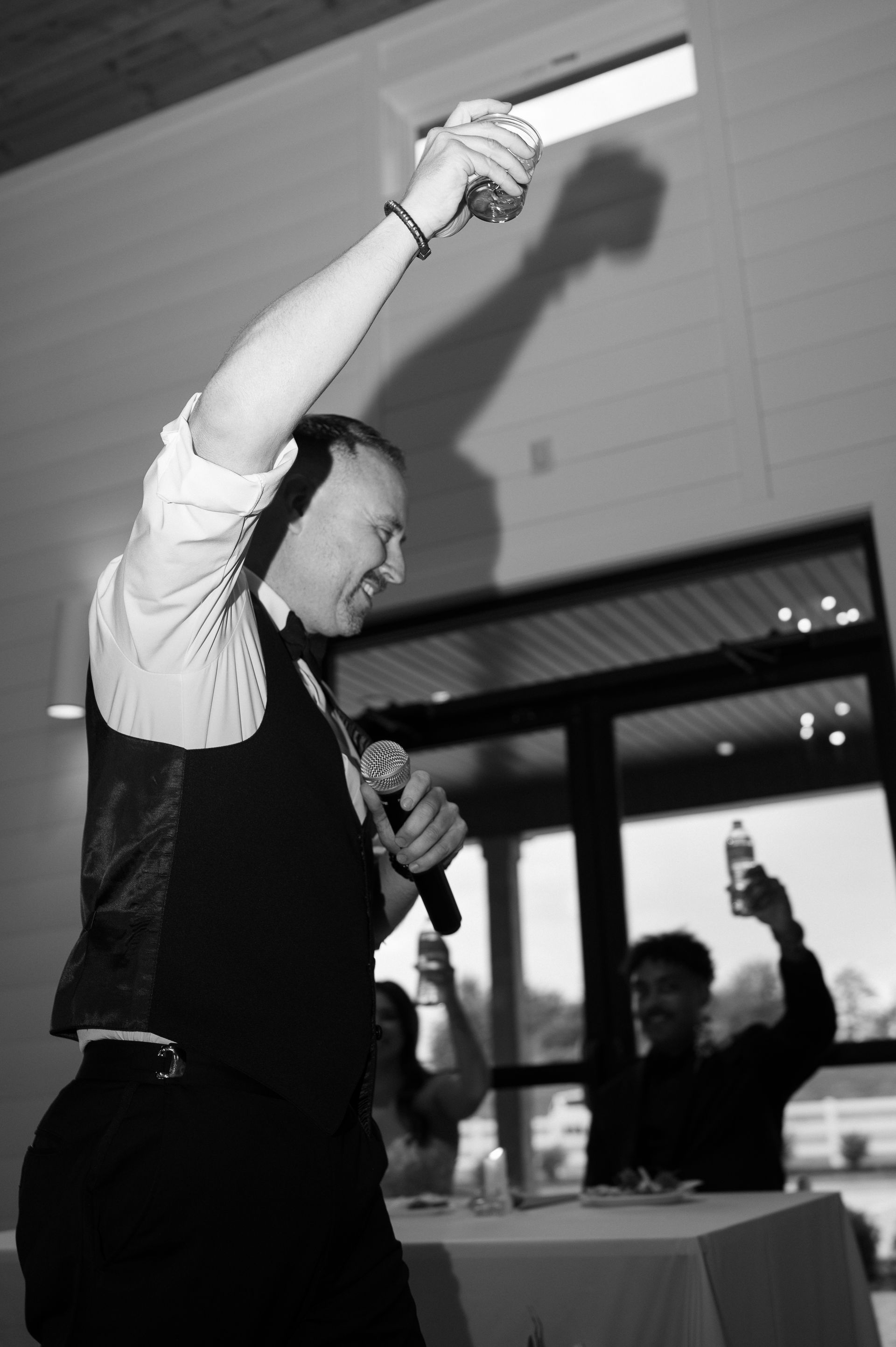 A man in a suit is holding a microphone up in the air