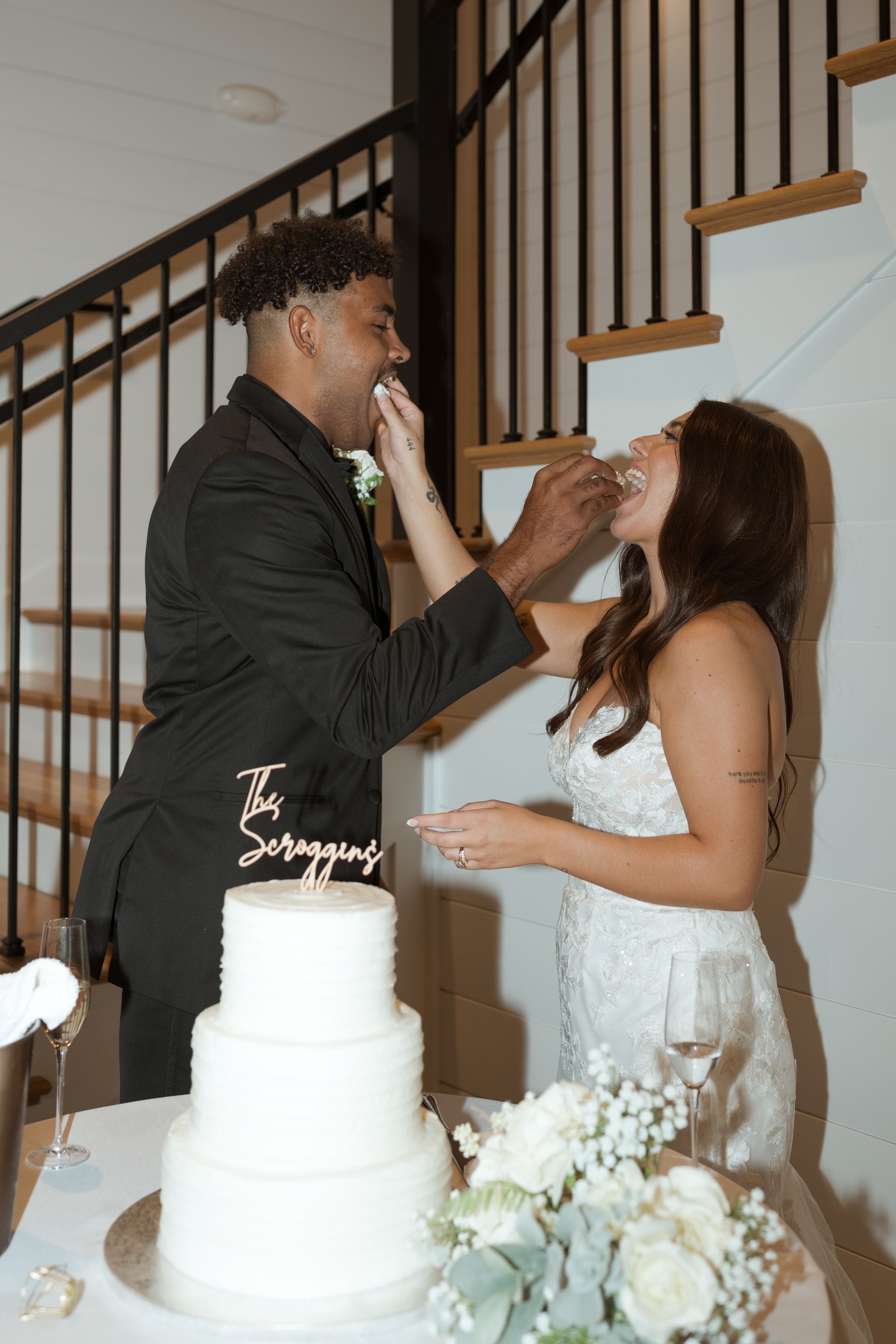 A bride and groom are feeding each other cake at their wedding reception.