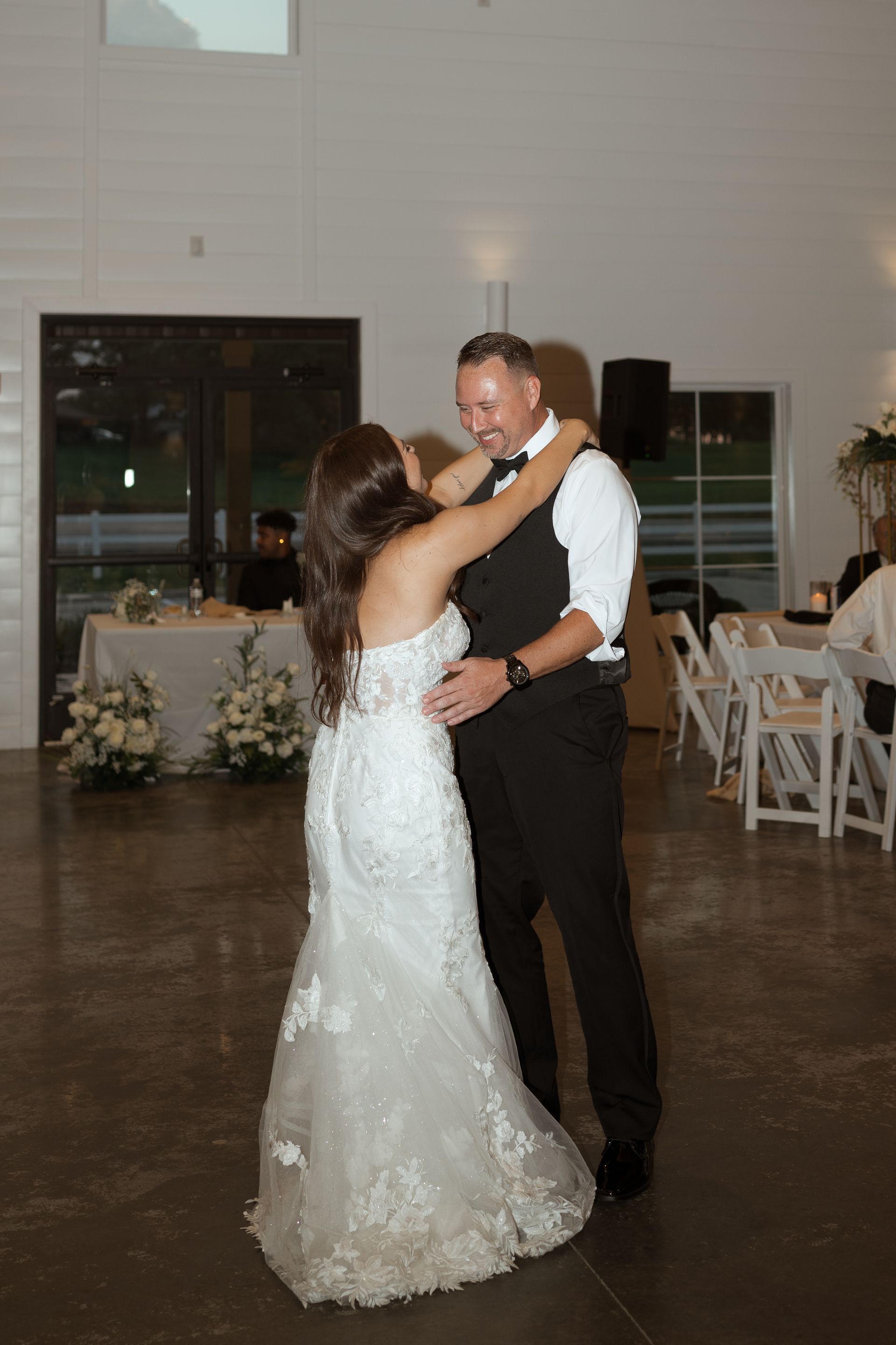 A bride and groom are dancing together at their wedding reception.