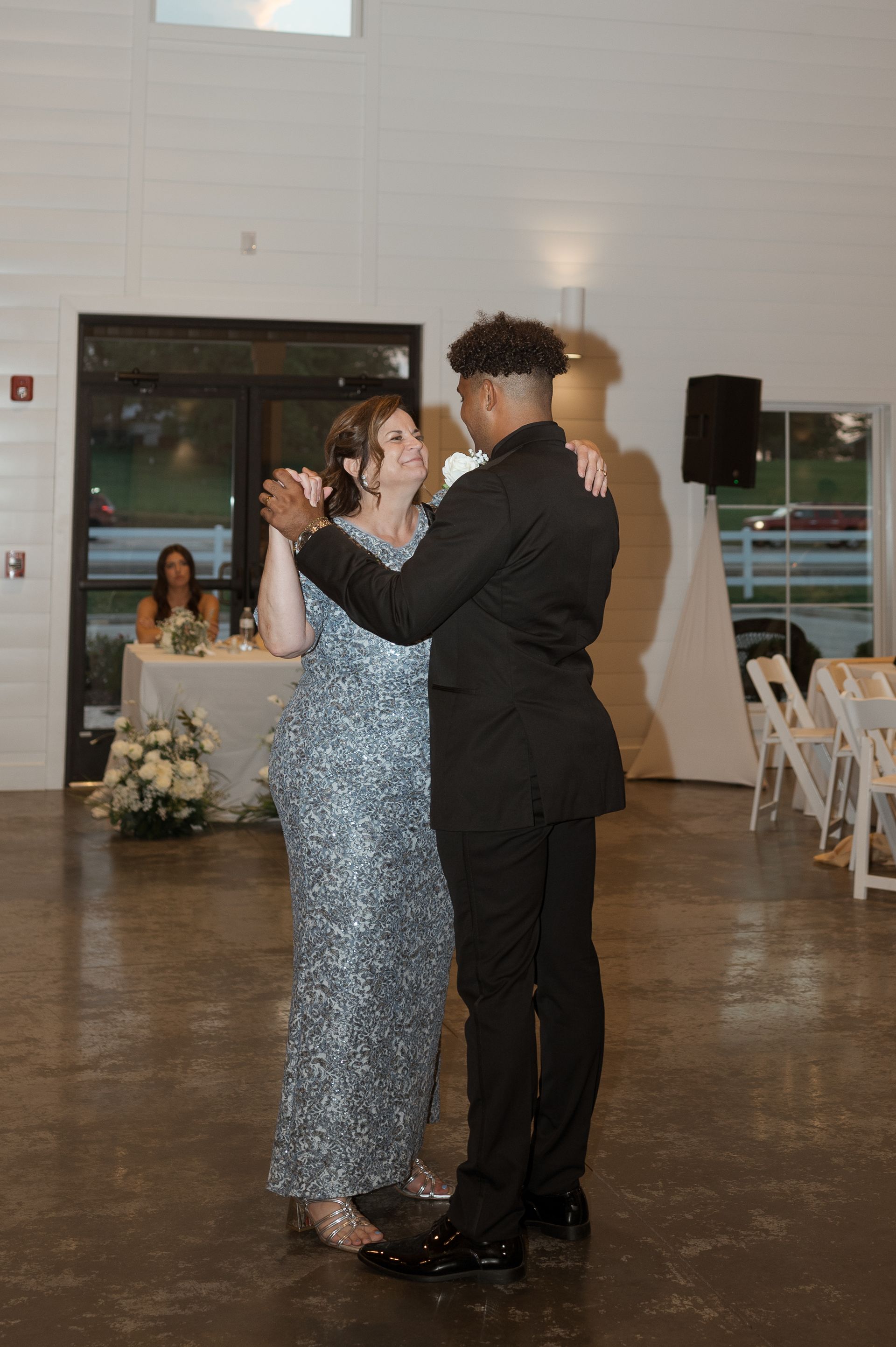 A man and a woman are dancing together at a wedding reception.