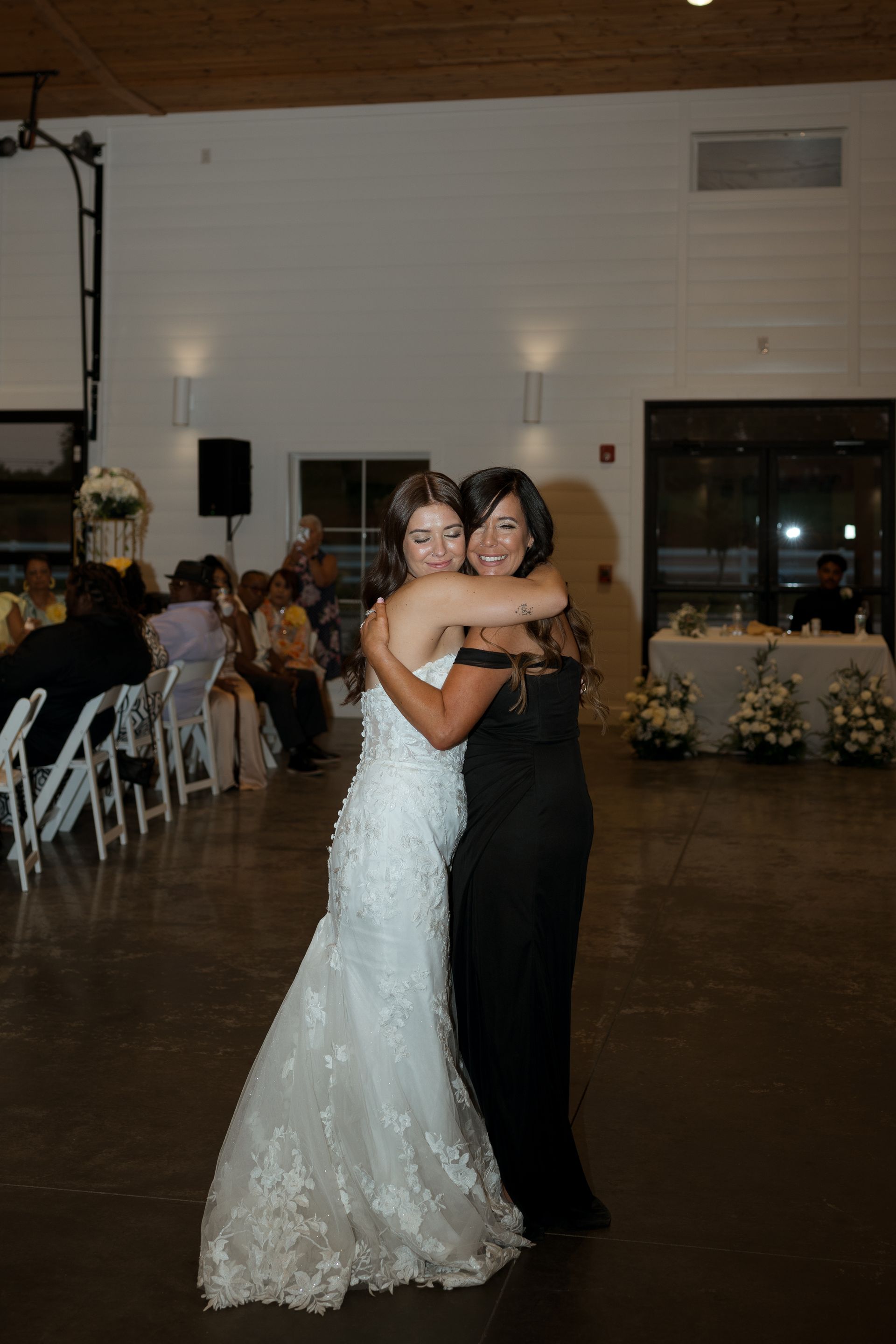 A bride and her mother are dancing together at a wedding reception.