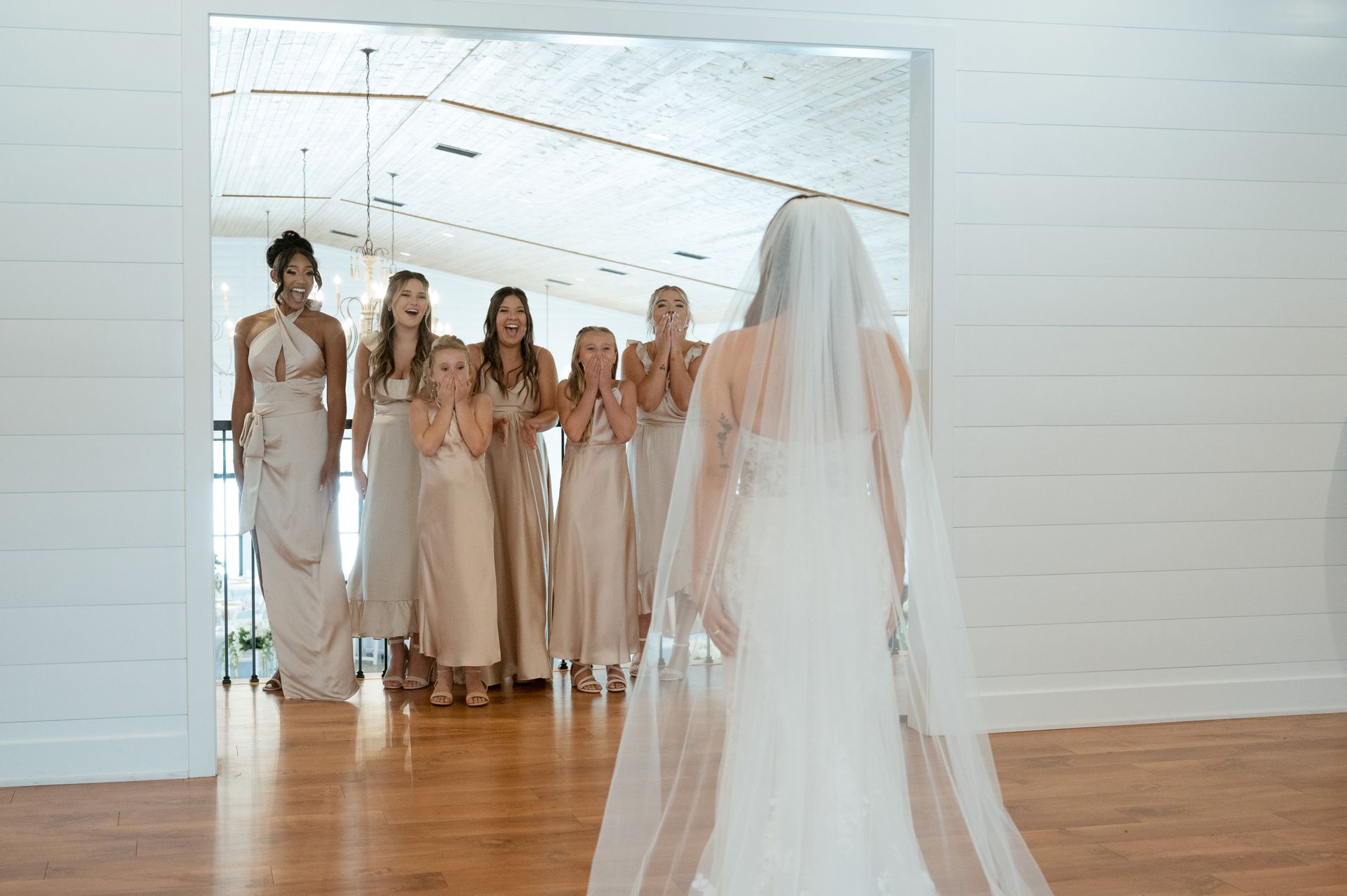 A bride and her bridesmaids are standing in a room.