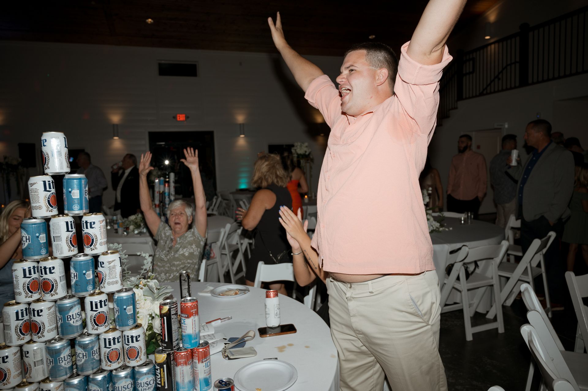 A man stands in front of a stack of bud light cans