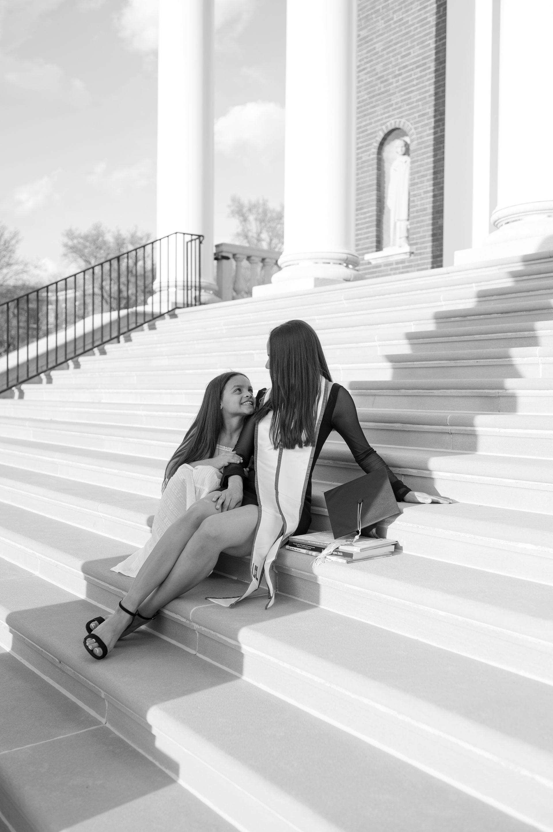Two women are sitting on the steps of a building.