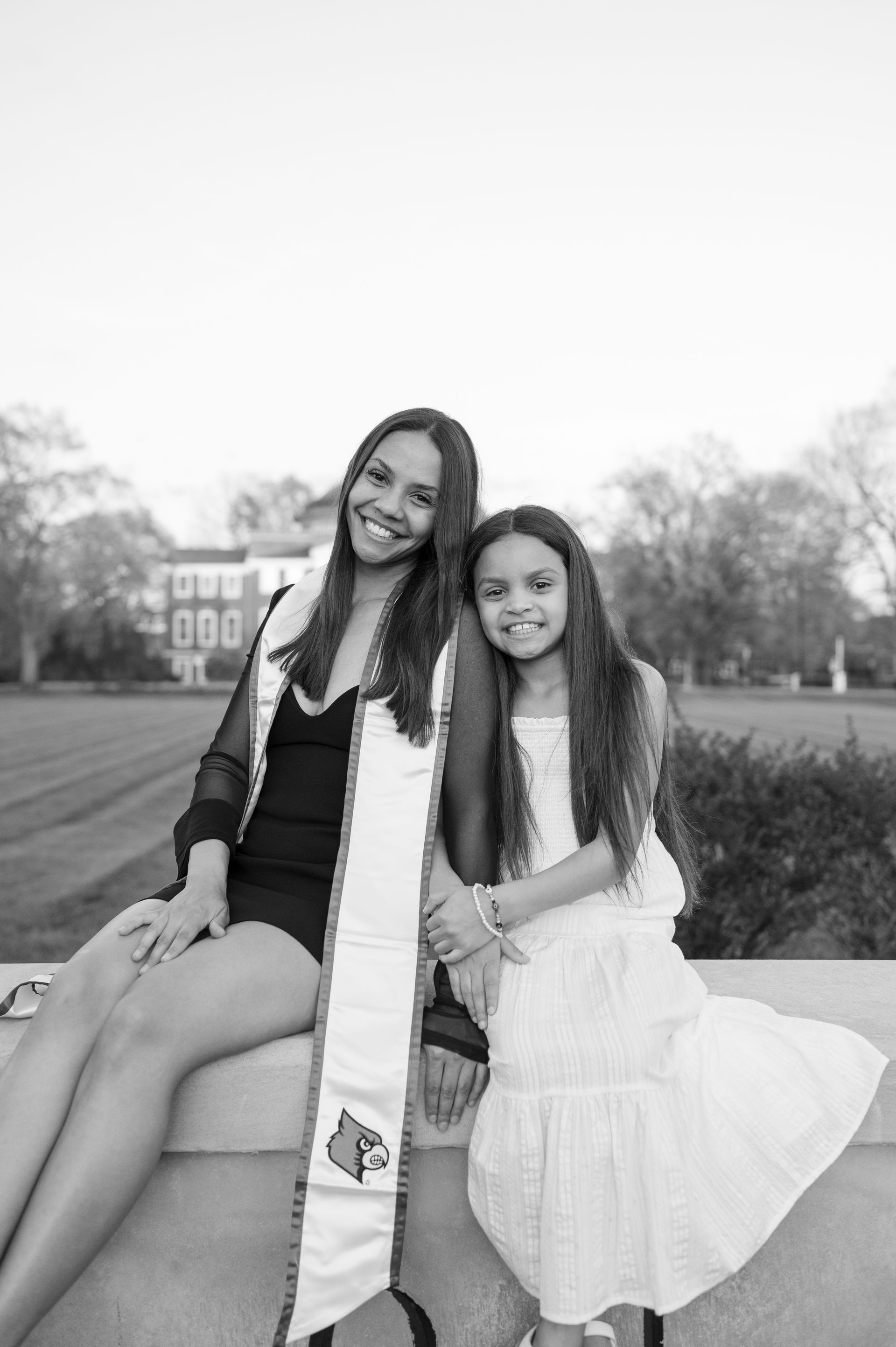 A black and white photo of two women sitting next to each other.