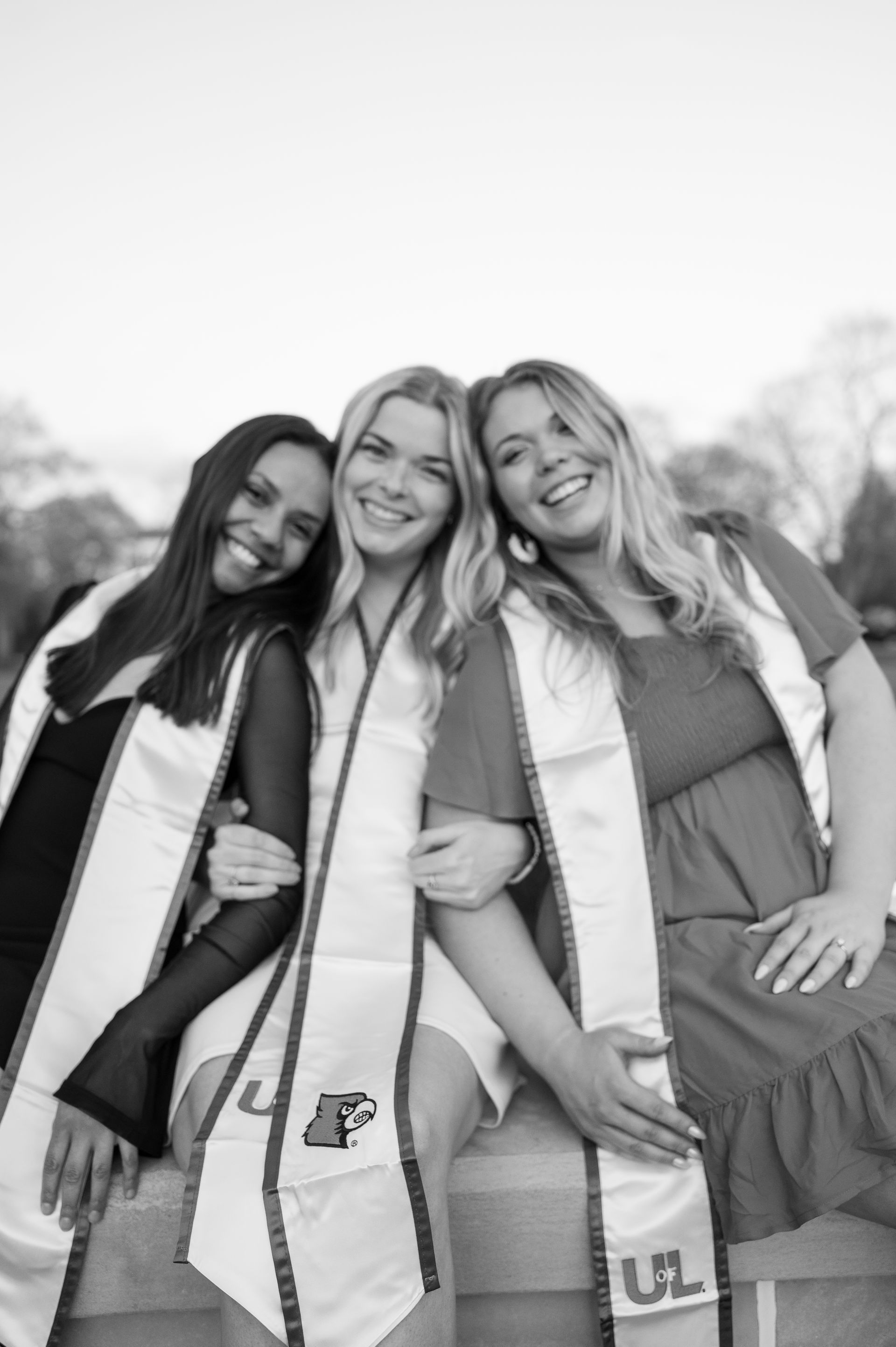 Three women in graduation gowns are posing for a picture together.