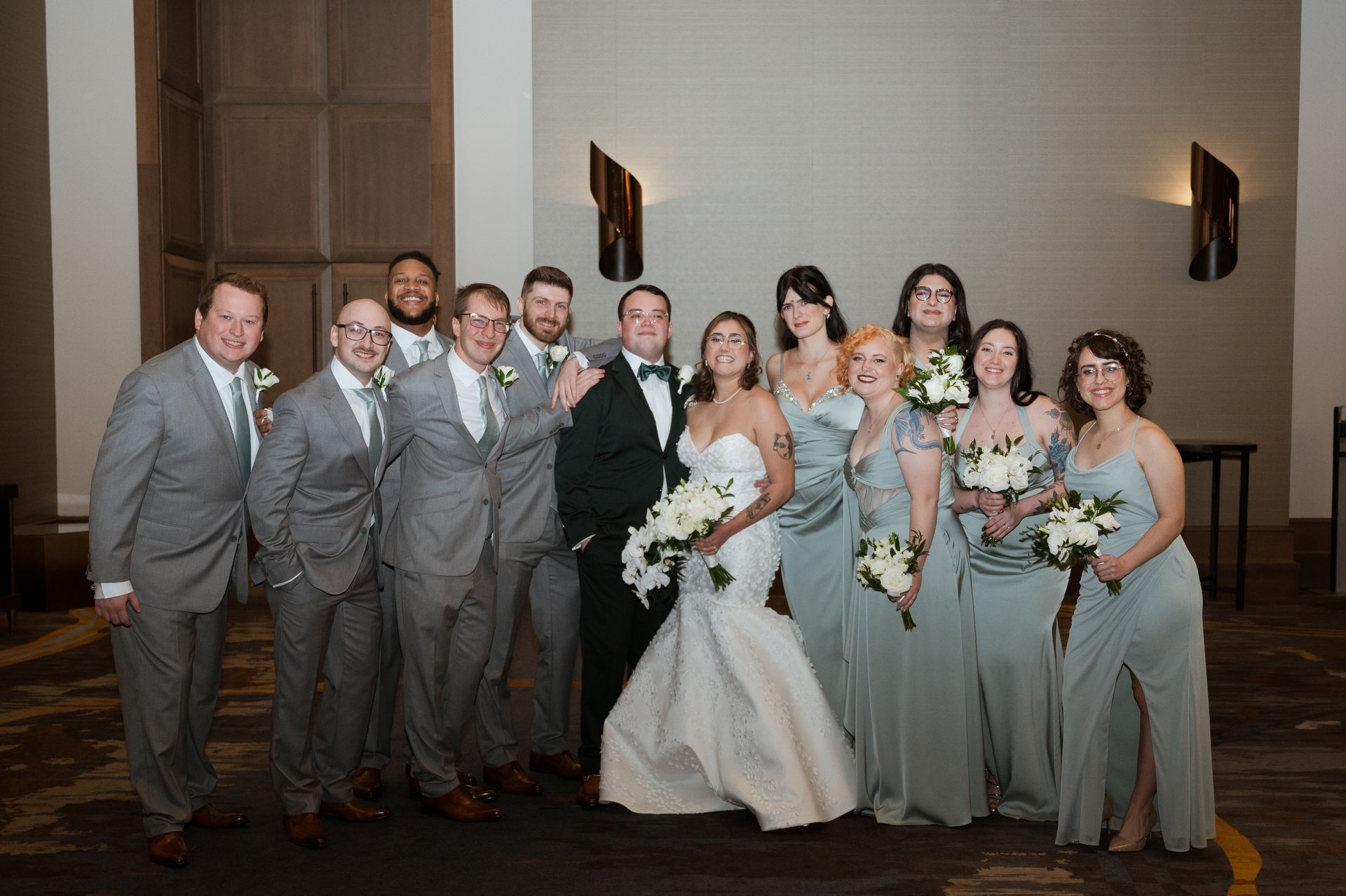 The bride and groom are posing for a picture with their wedding party.