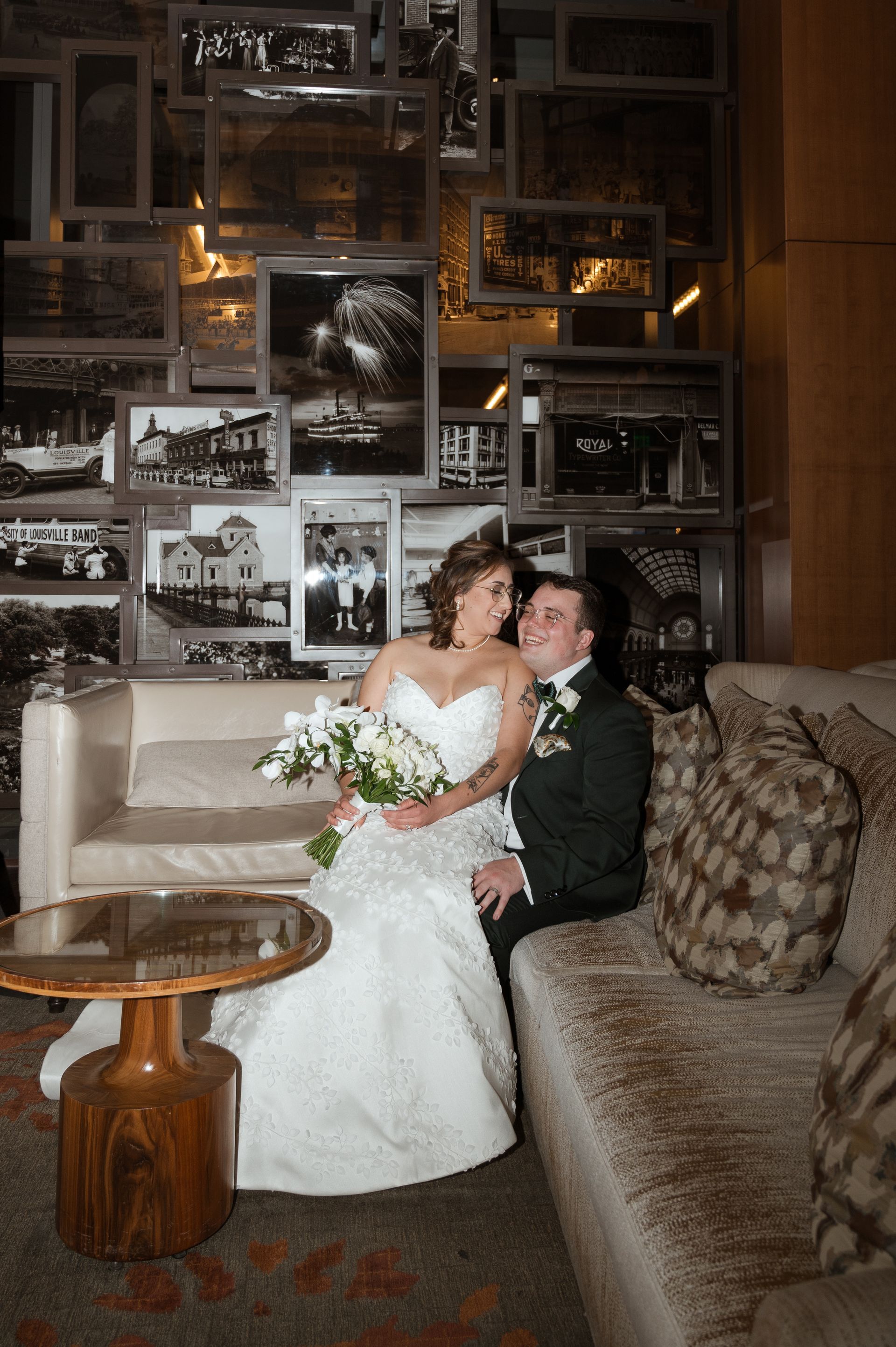 A bride and groom are posing for a picture on a couch.