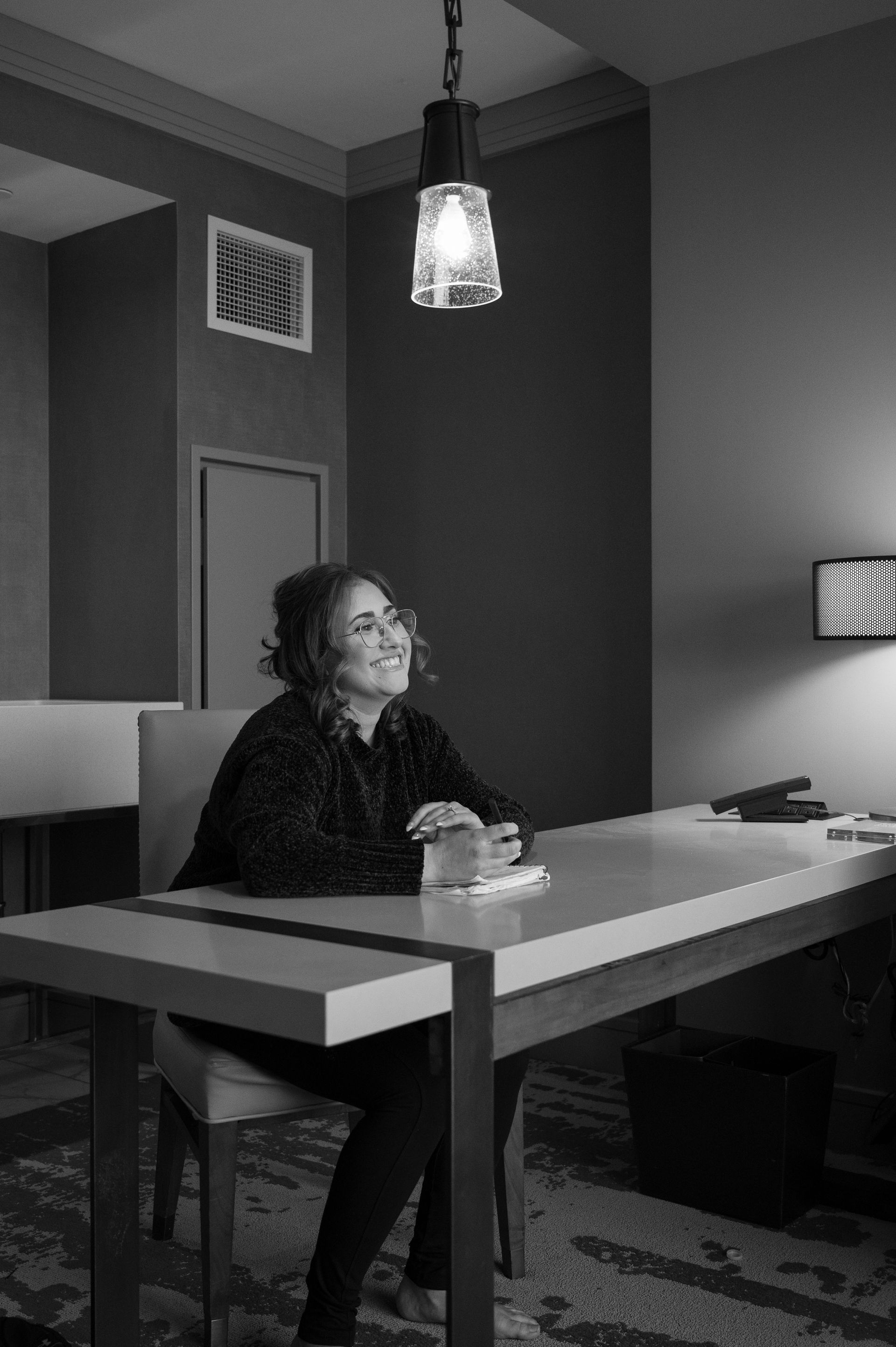 A black and white photo of a woman sitting at a table