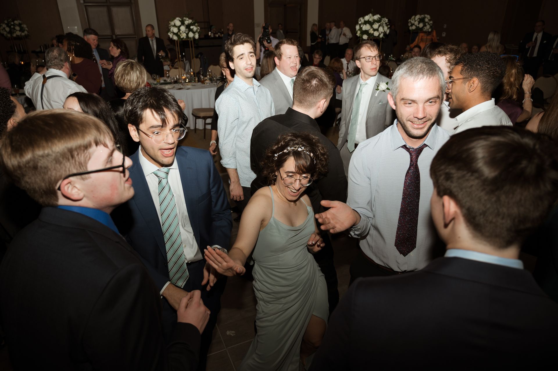 A group of people are dancing in a room at a party.