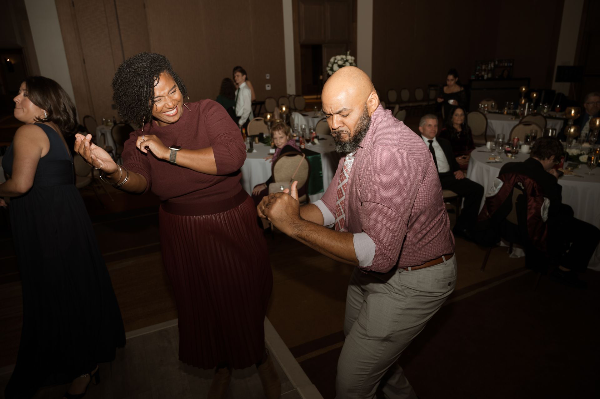 A man and a woman are dancing together at a party.