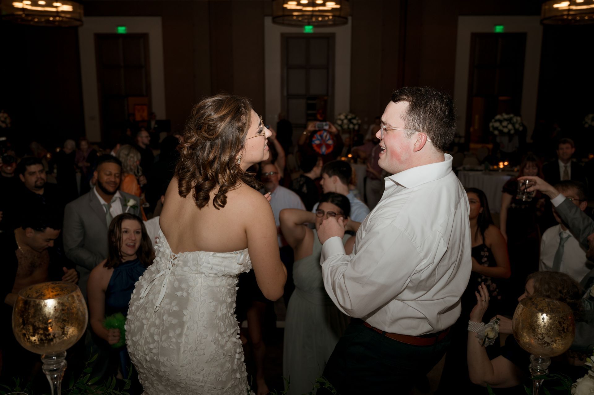 A bride and groom are dancing at their wedding reception.