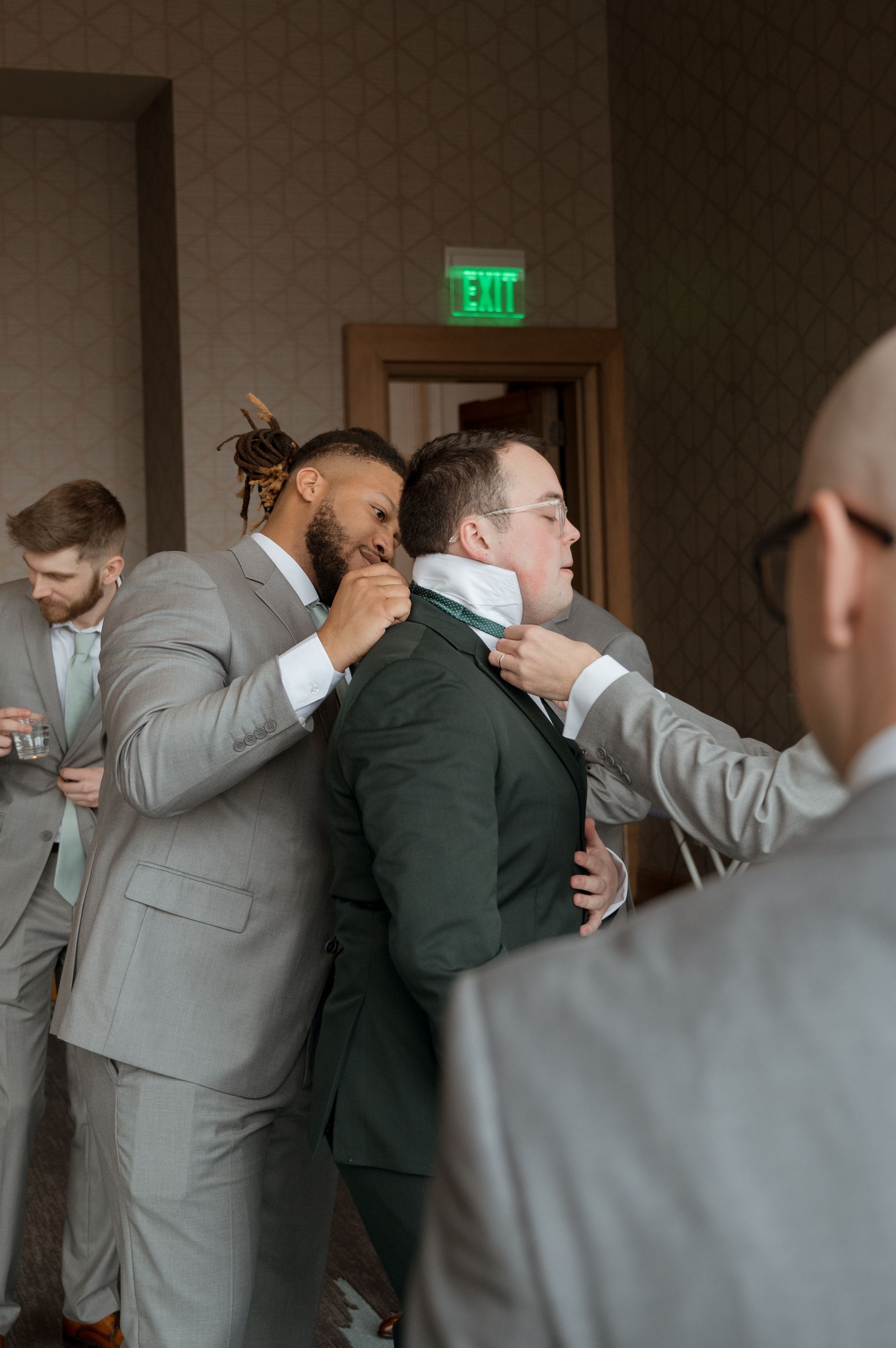 A group of men in suits are getting ready for a wedding.