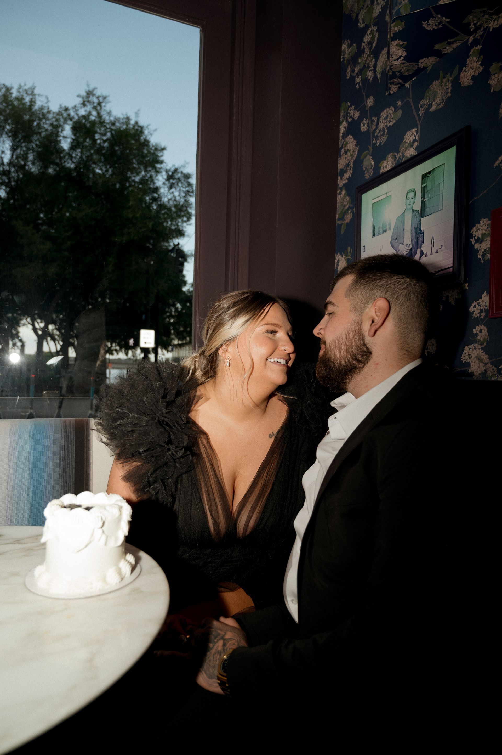 A man and a woman are sitting at a table looking at each other.