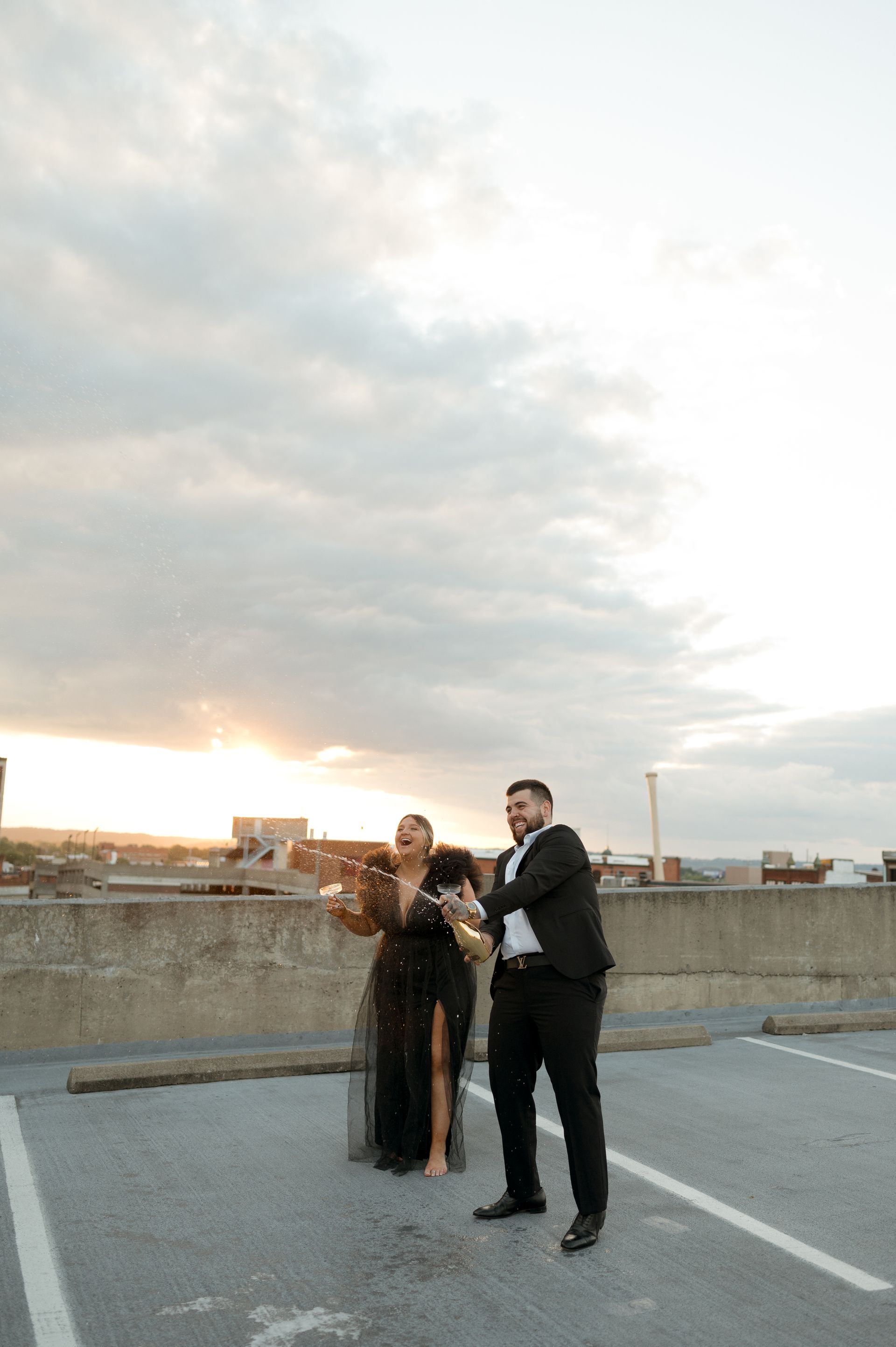 A man and a woman are standing in a parking lot.