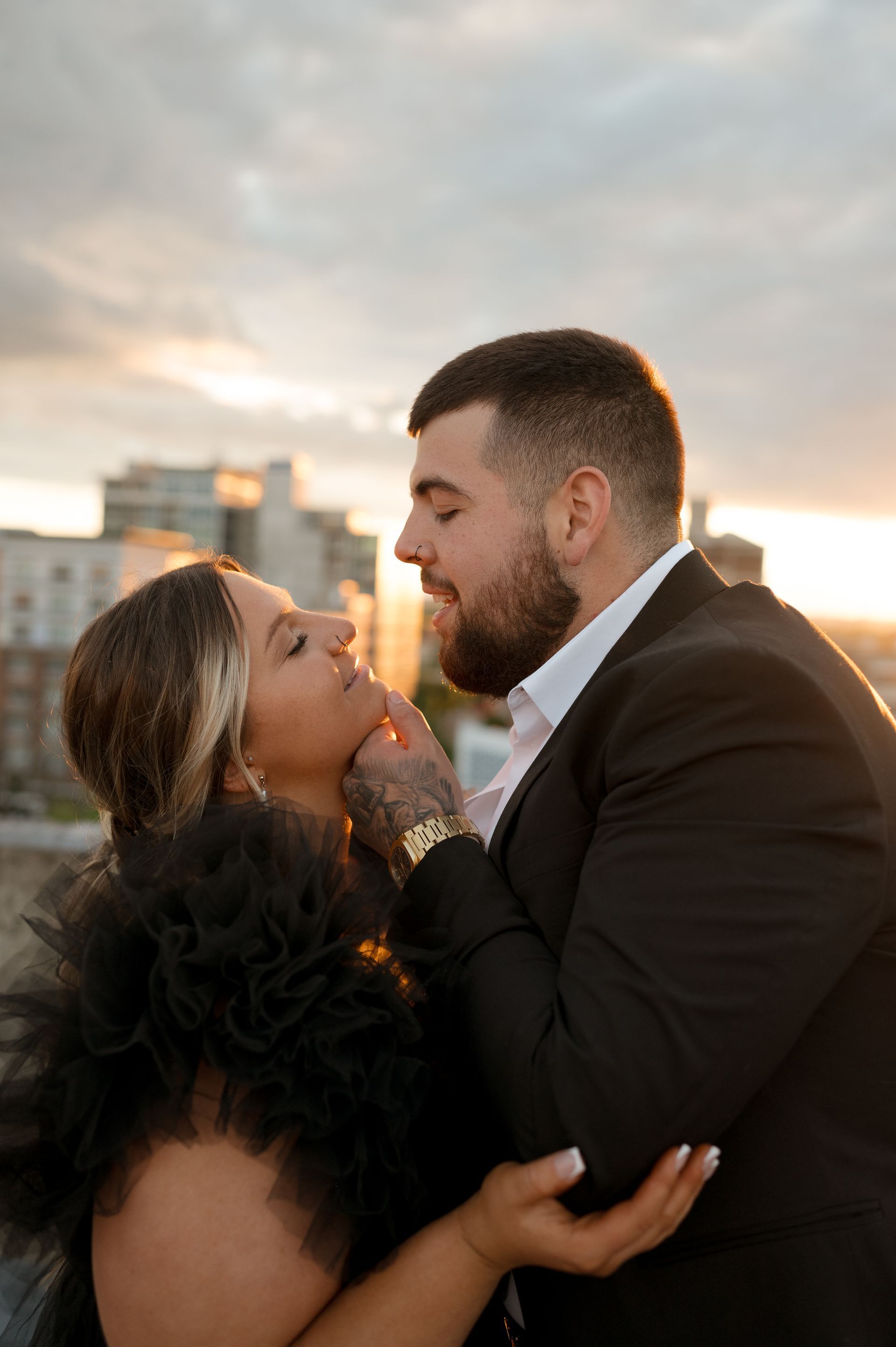 A man and a woman are kissing in front of a city skyline.