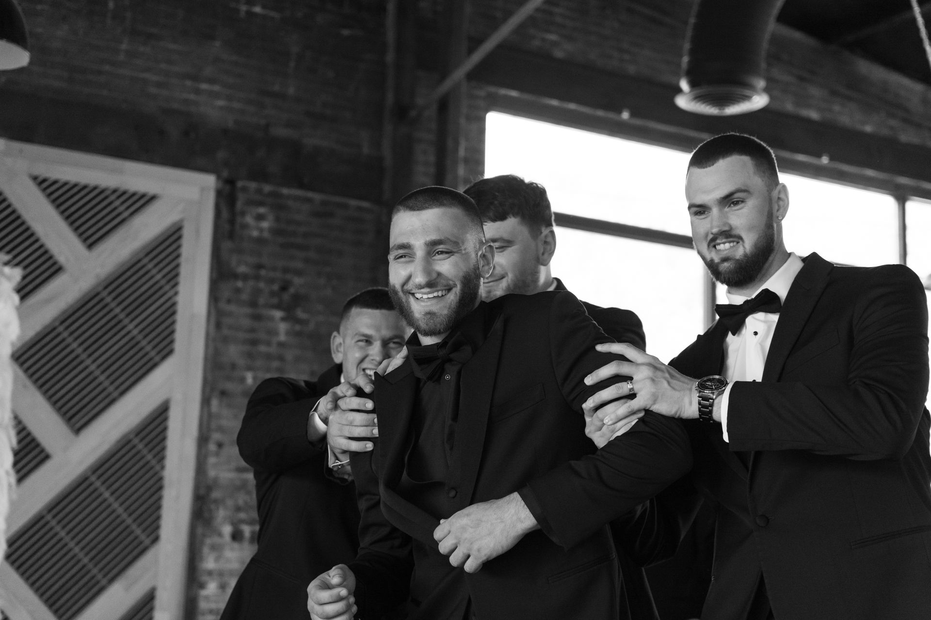 A group of men in suits and bow ties are posing for a picture.