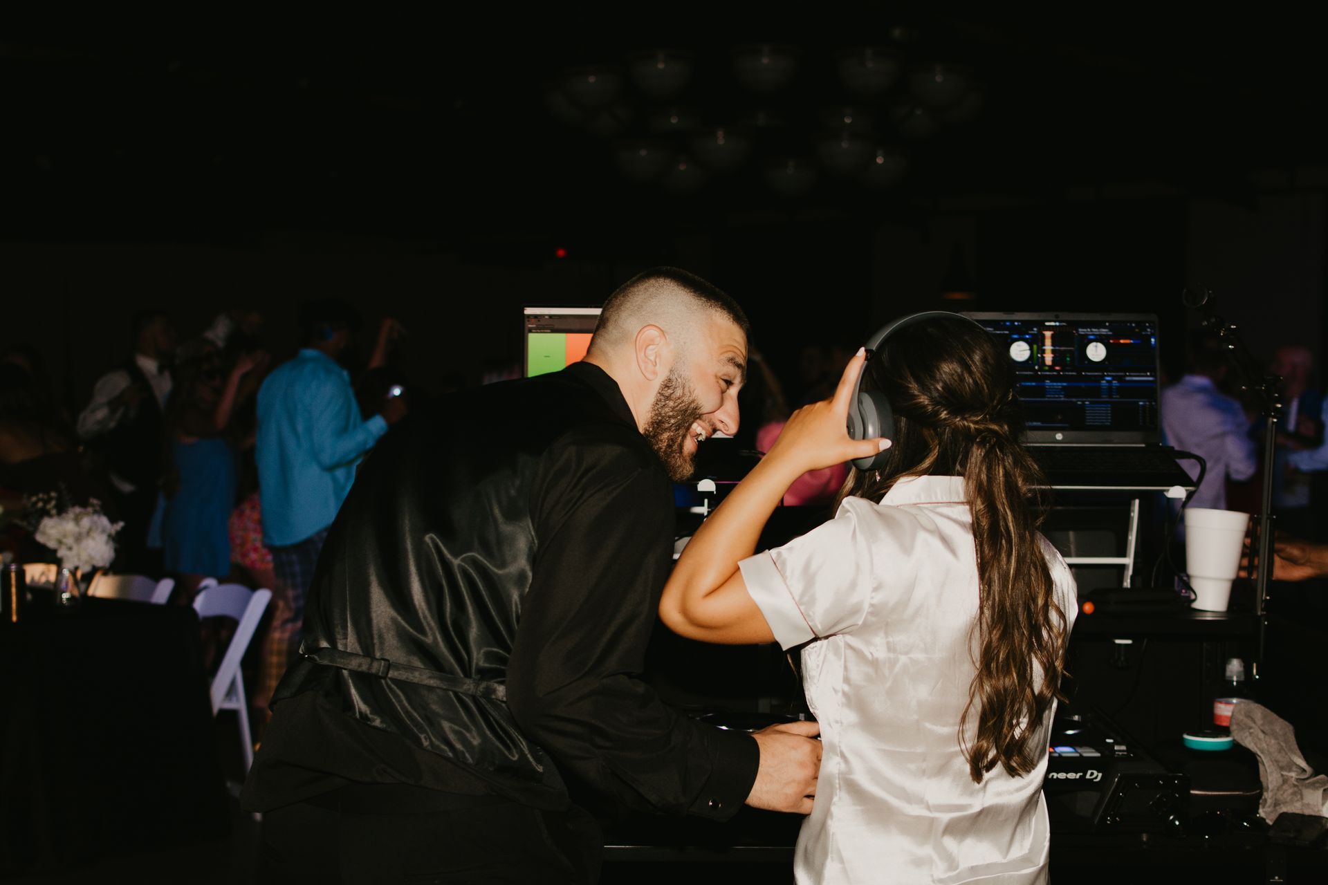 A man and a woman are dancing at a wedding reception.