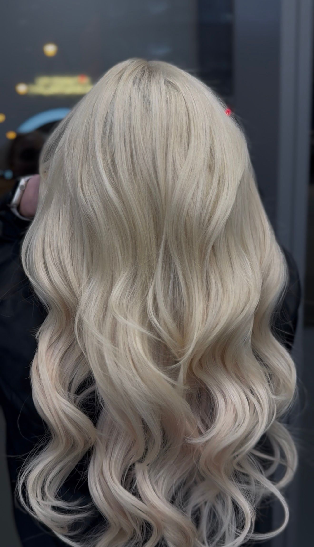 Blonde wavy hair cascading down. Outside setting with reflective background.